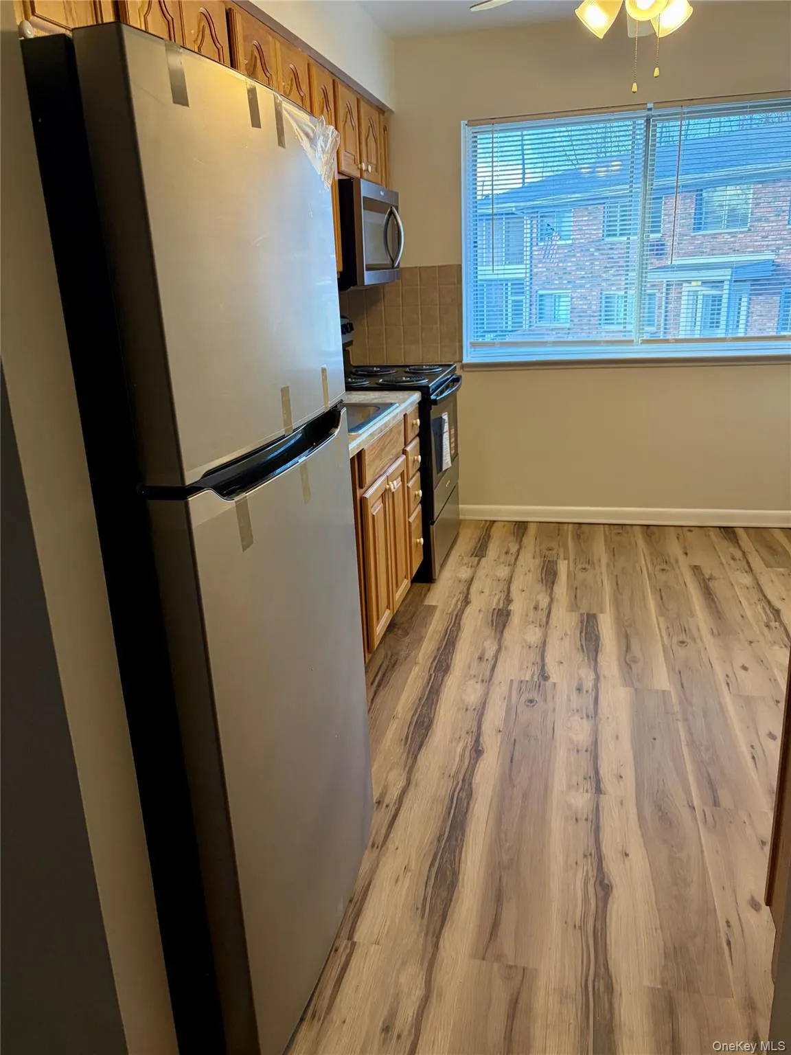 Kitchen featuring stainless steel refrigerator, laminate wood finished floors Kitchen featuring stainless steel refrigerator, laminate wood finished floors