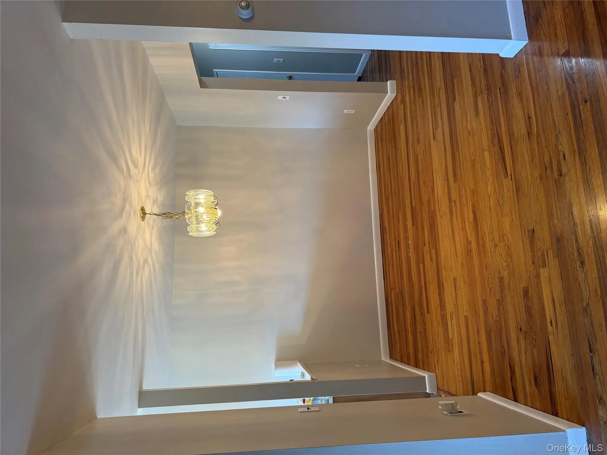 Unfurnished dining area with hardwood floors and a chandelier Unfurnished dining area with hardwood floors and a chandelier