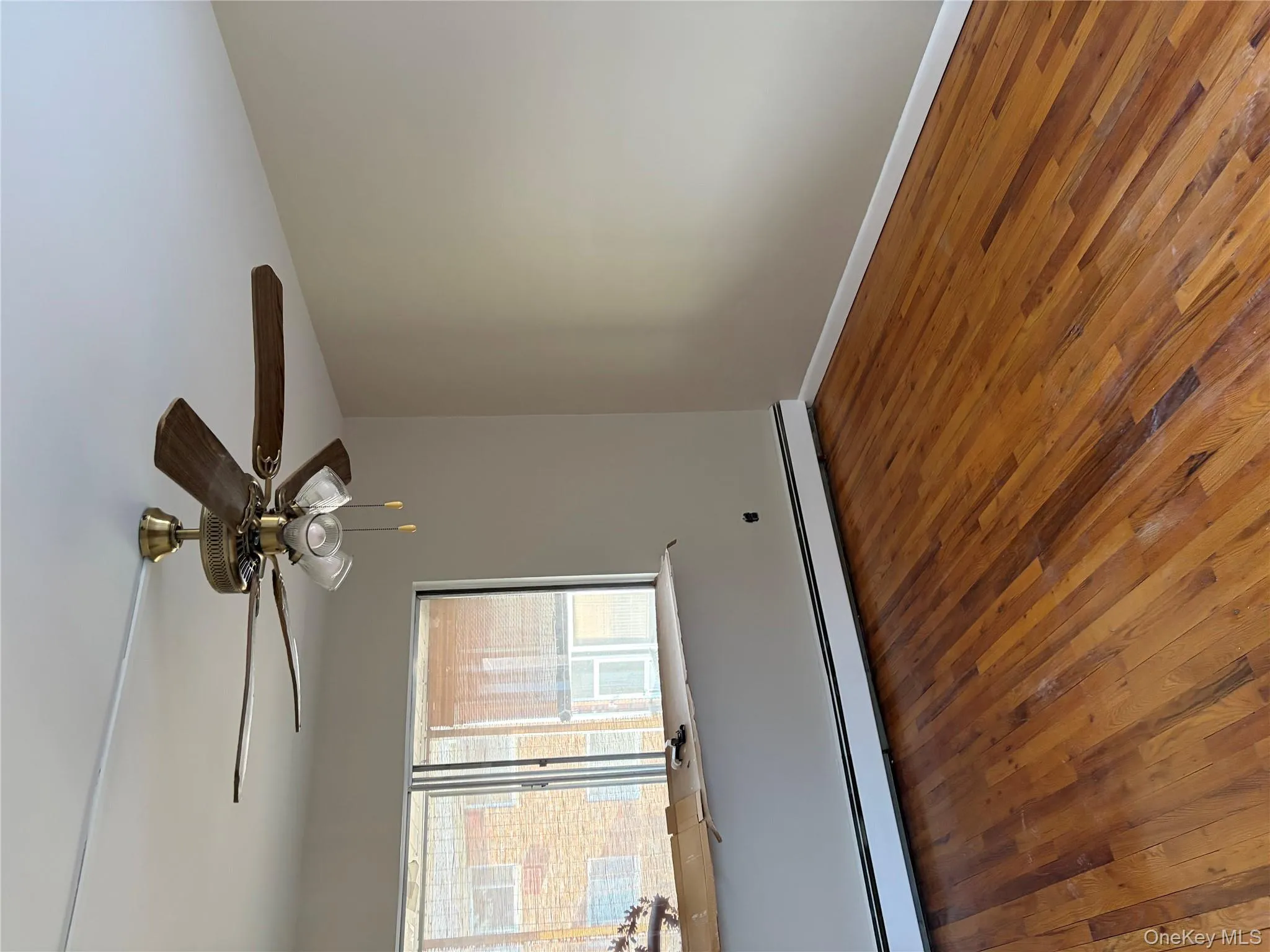Unfurnished room featuring a baseboard radiator, dark wood-style flooring, and ceiling fan Unfurnished room featuring a baseboard radiator, dark wood-style flooring, and ceiling fan