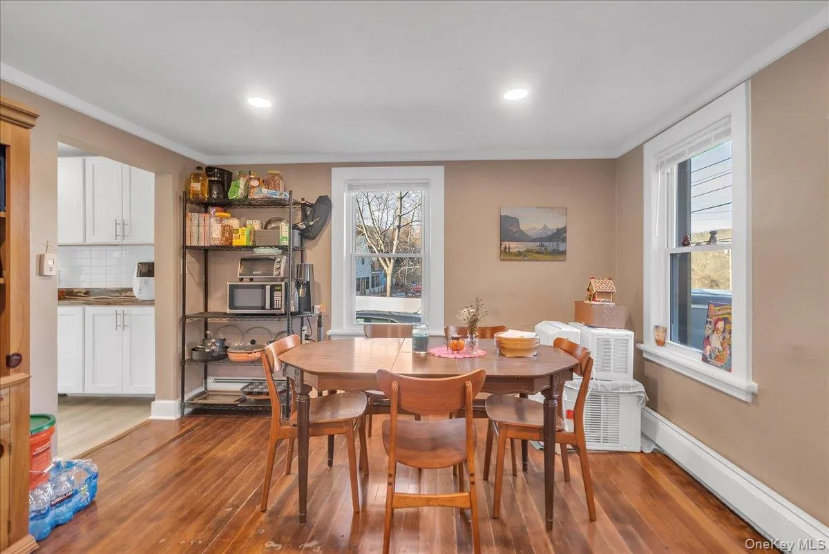 Dining area featuring hardwood / wood-style flooring, a baseboard heating unit, plenty of natural light, ornamental molding, and recessed lighting Dining area featuring hardwood / wood-style flooring, a baseboard heating unit, plenty of natural light, ornamental molding, and recessed lighting