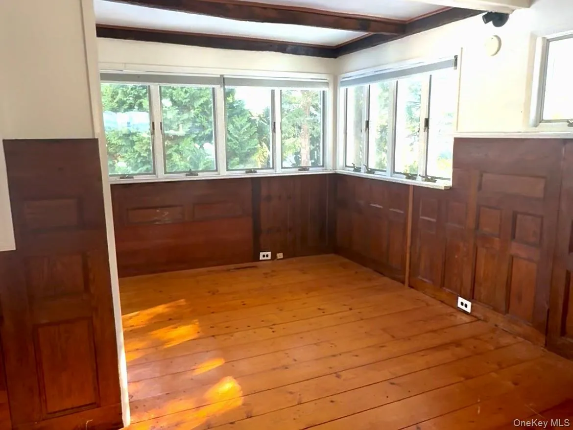 Spare room featuring light wood-style flooring and beam ceiling Spare room featuring light wood-style flooring and beam ceiling