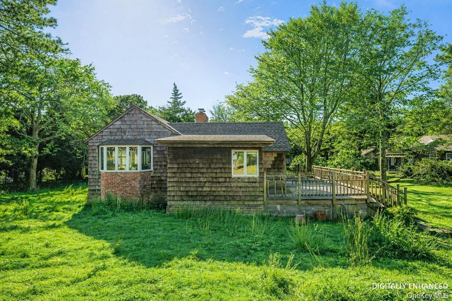 View of side of home with a yard, a wooden deck, and a chimney - Digitally Enhanced View of side of home with a yard, a wooden deck, and a chimney - Digitally Enhanced