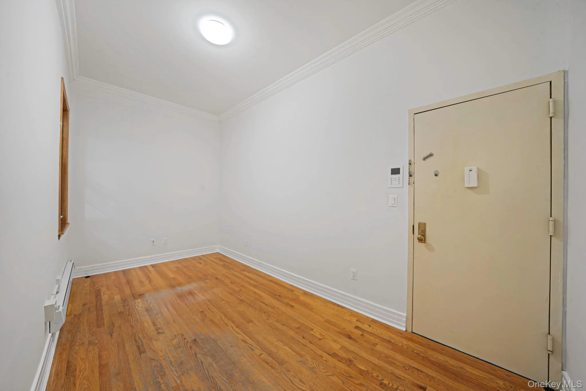 Unfurnished room with wood finished floors and crown molding Unfurnished room with wood finished floors and crown molding