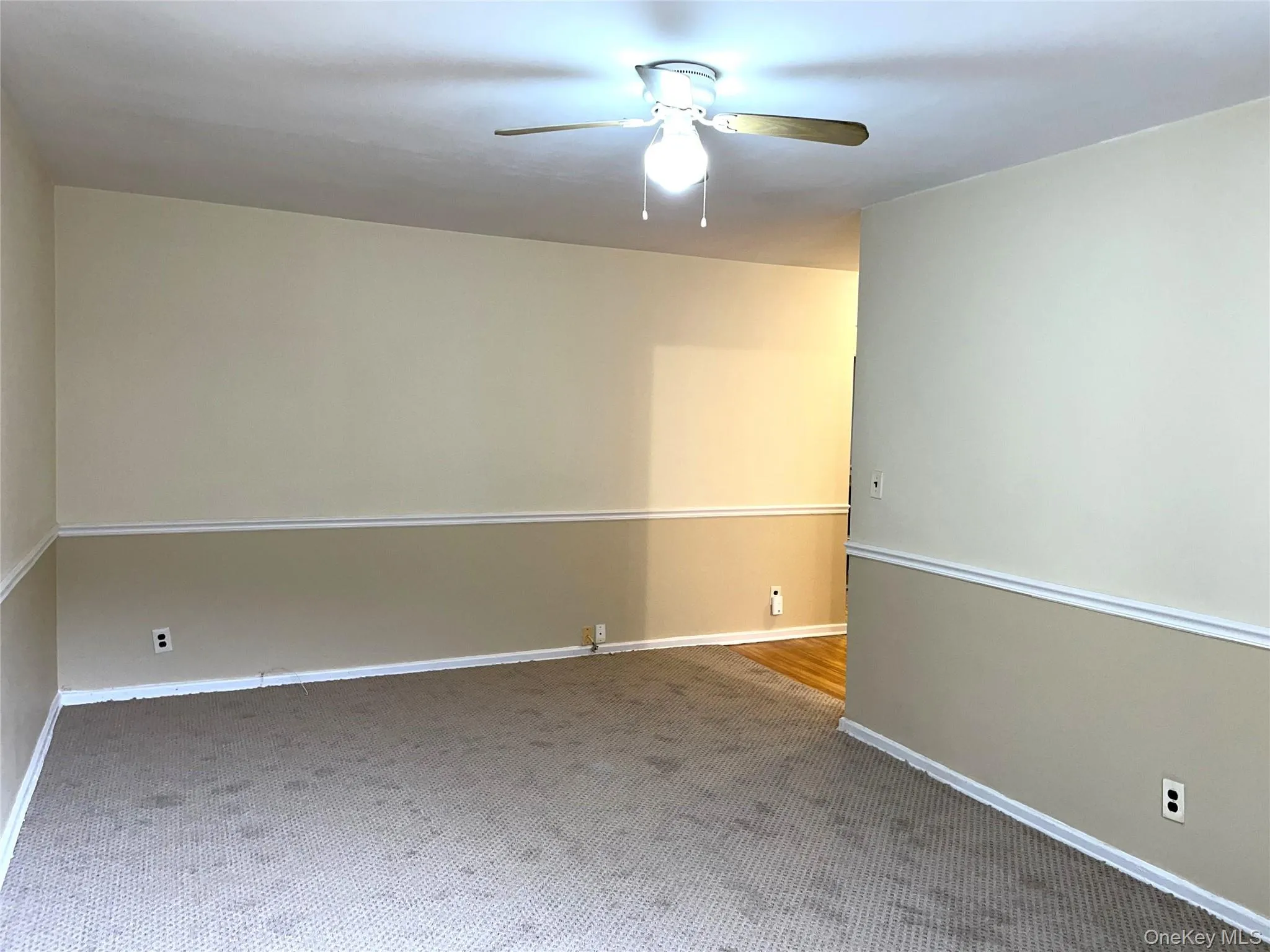 Carpeted empty room with ceiling fan Carpeted empty room with ceiling fan