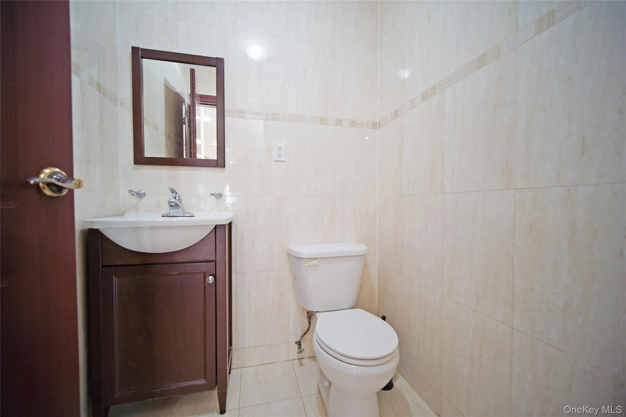 Bathroom with vanity, tile patterned flooring, and tile walls Bathroom with vanity, tile patterned flooring, and tile walls