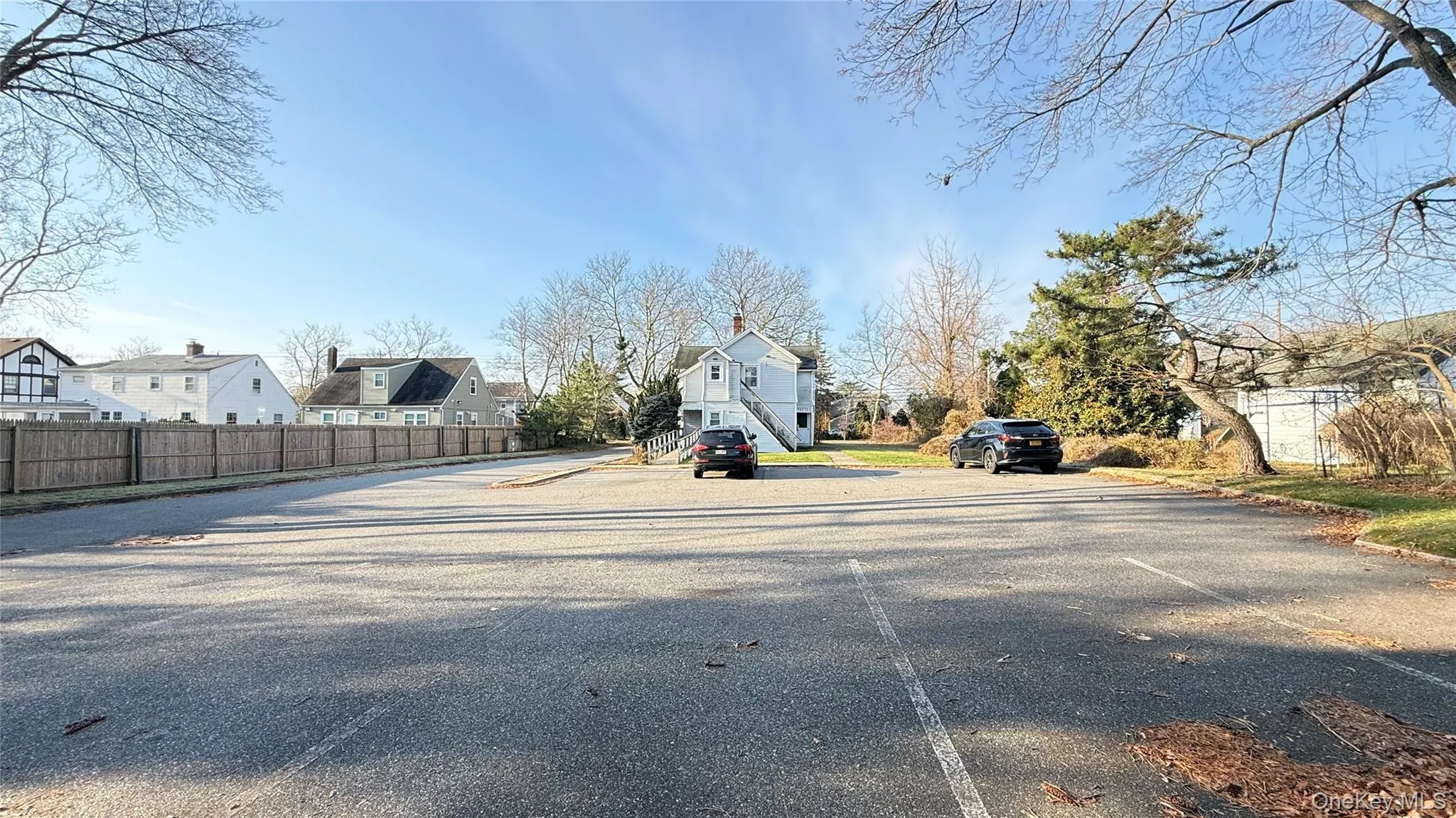 View of asphalt road featuring a residential view and curbs View of asphalt road featuring a residential view and curbs