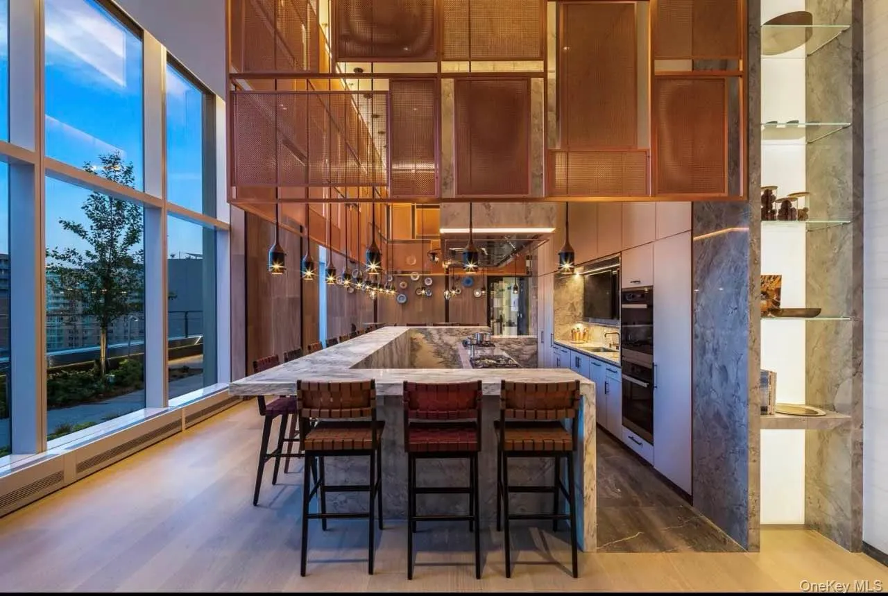 Kitchen featuring pendant lighting, a kitchen island, floor to ceiling windows, a kitchen bar, and dark wood finished floors Kitchen featuring pendant lighting, a kitchen island, floor to ceiling windows, a kitchen bar, and dark wood finished floors