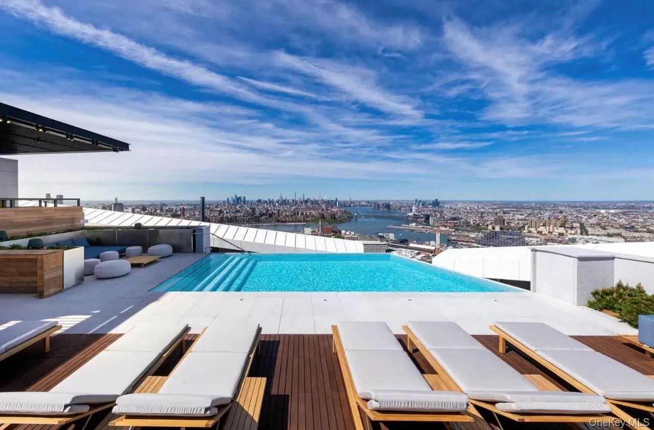 View of swimming pool with an infinity pool, a patio area, and a rooftop deck View of swimming pool with an infinity pool, a patio area, and a rooftop deck