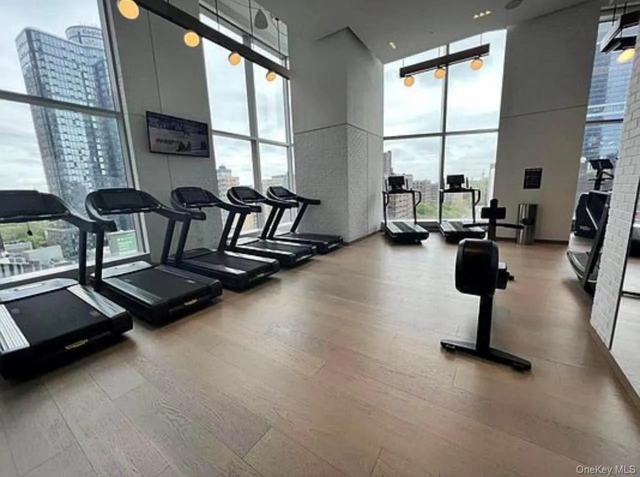 Workout area featuring a high ceiling and a wall of windows Workout area featuring a high ceiling and a wall of windows