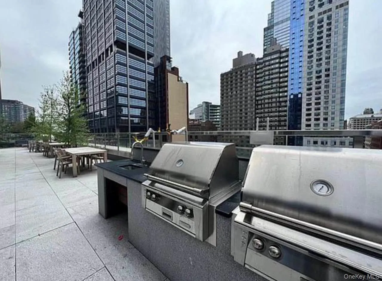 View of patio featuring a view of city, outdoor dining space, and exterior kitchen View of patio featuring a view of city, outdoor dining space, and exterior kitchen