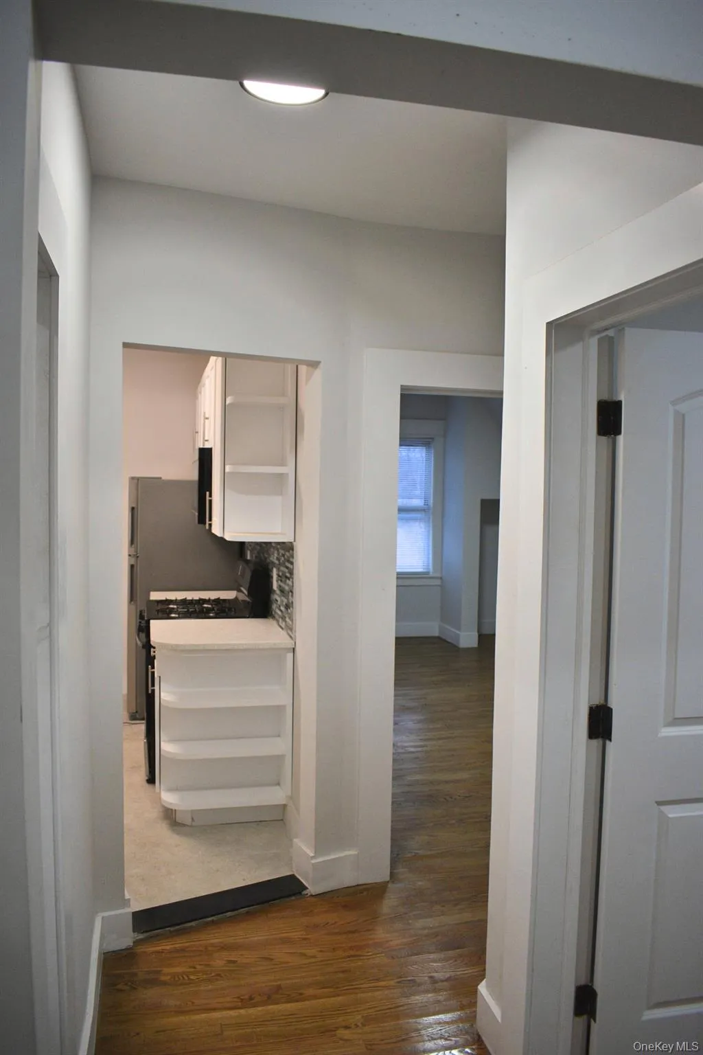 Hallway featuring dark wood-style flooring and baseboards Hallway featuring dark wood-style flooring and baseboards