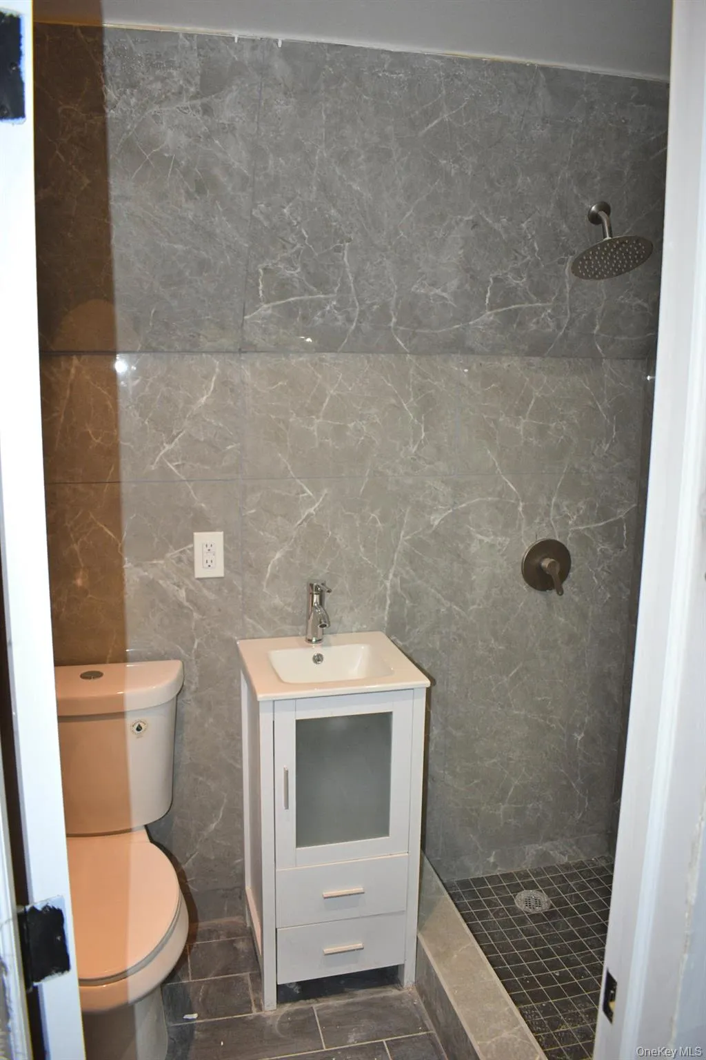Full bath with a marble finish shower, tile walls, and vanity Full bath with a marble finish shower, tile walls, and vanity