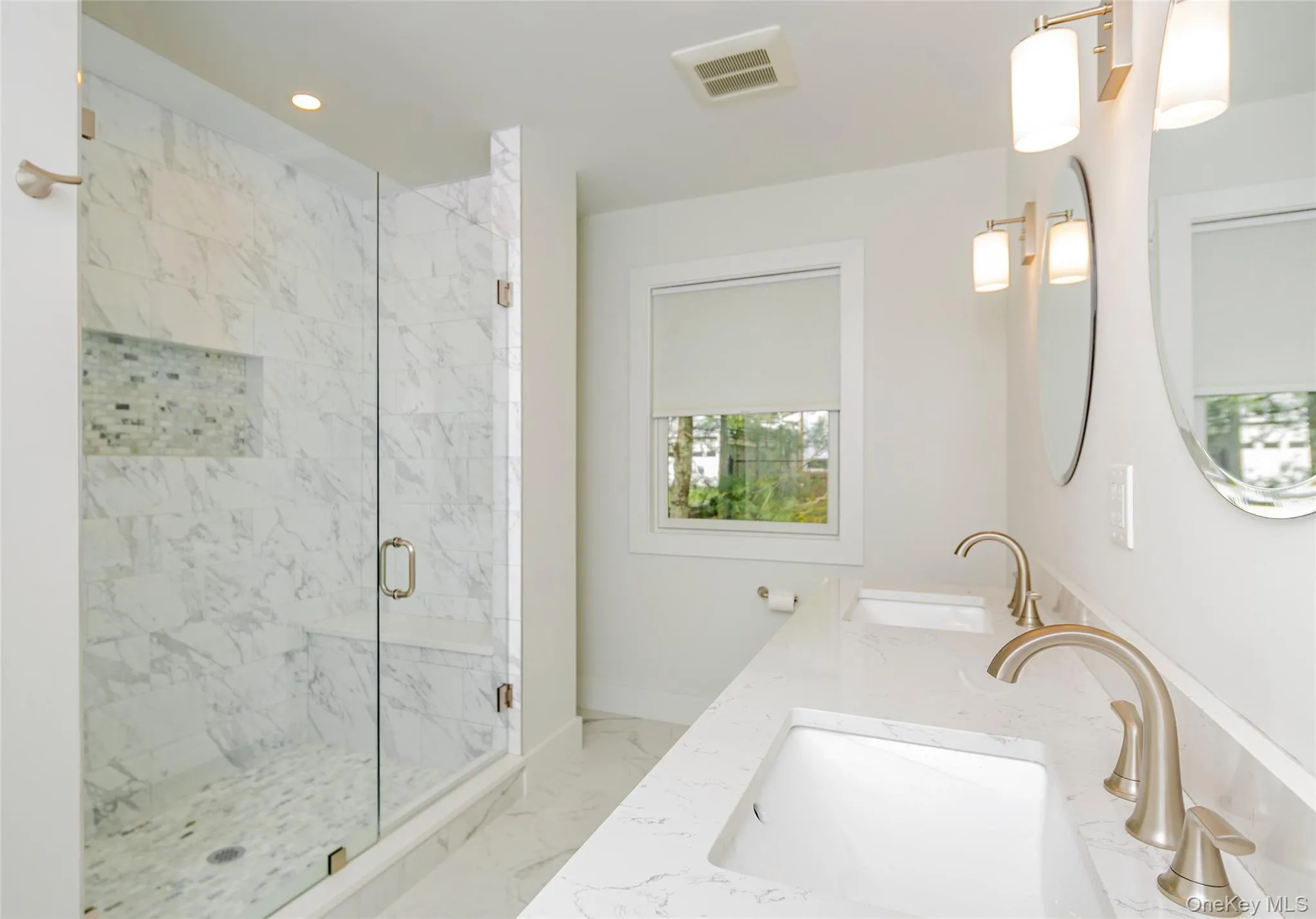 Bathroom featuring light marble finish flooring, a marble finish shower, double vanity, and recessed lighting Bathroom featuring light marble finish flooring, a marble finish shower, double vanity, and recessed lighting