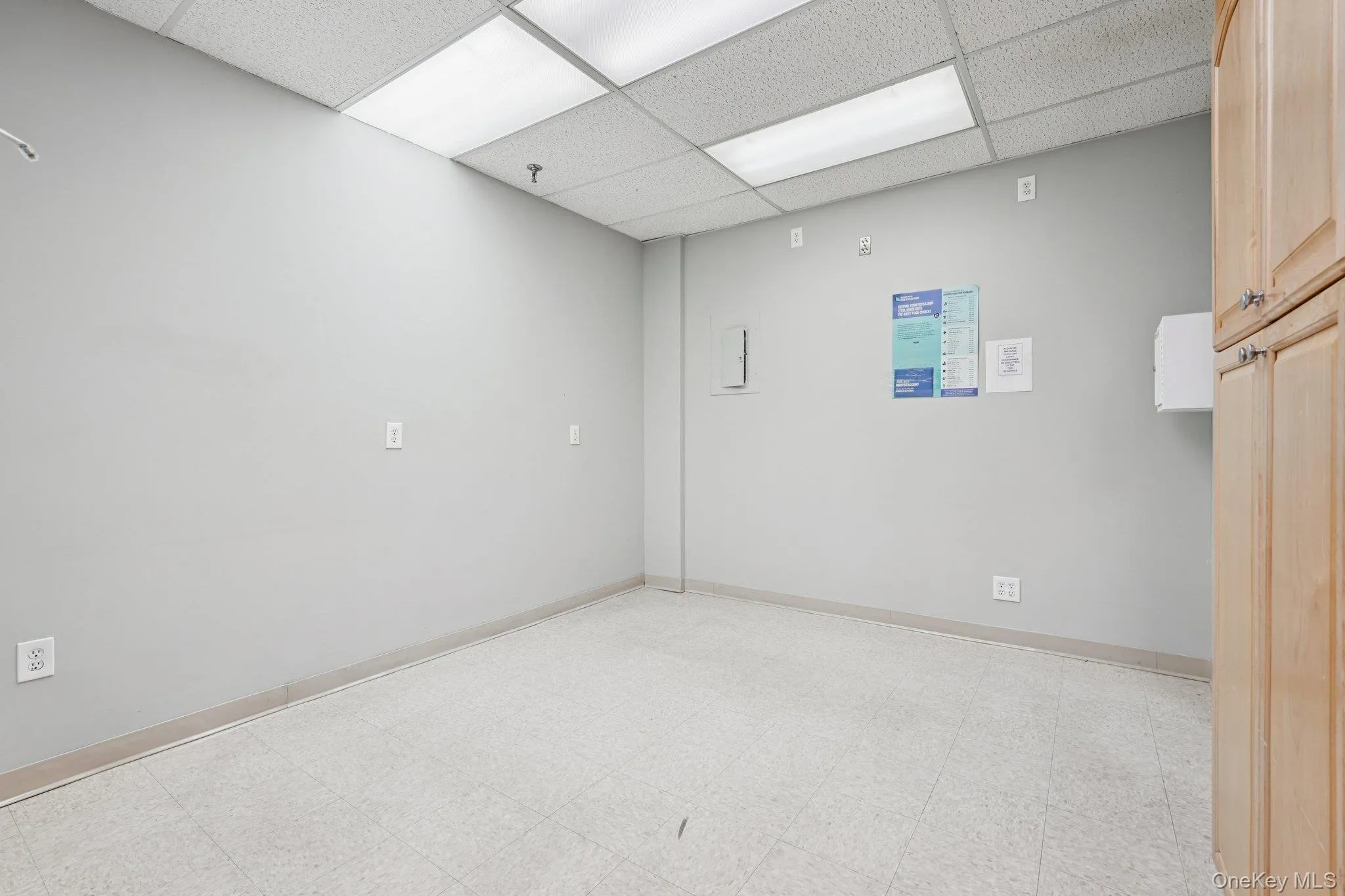Spare room featuring light floors and a drop ceiling Spare room featuring light floors and a drop ceiling