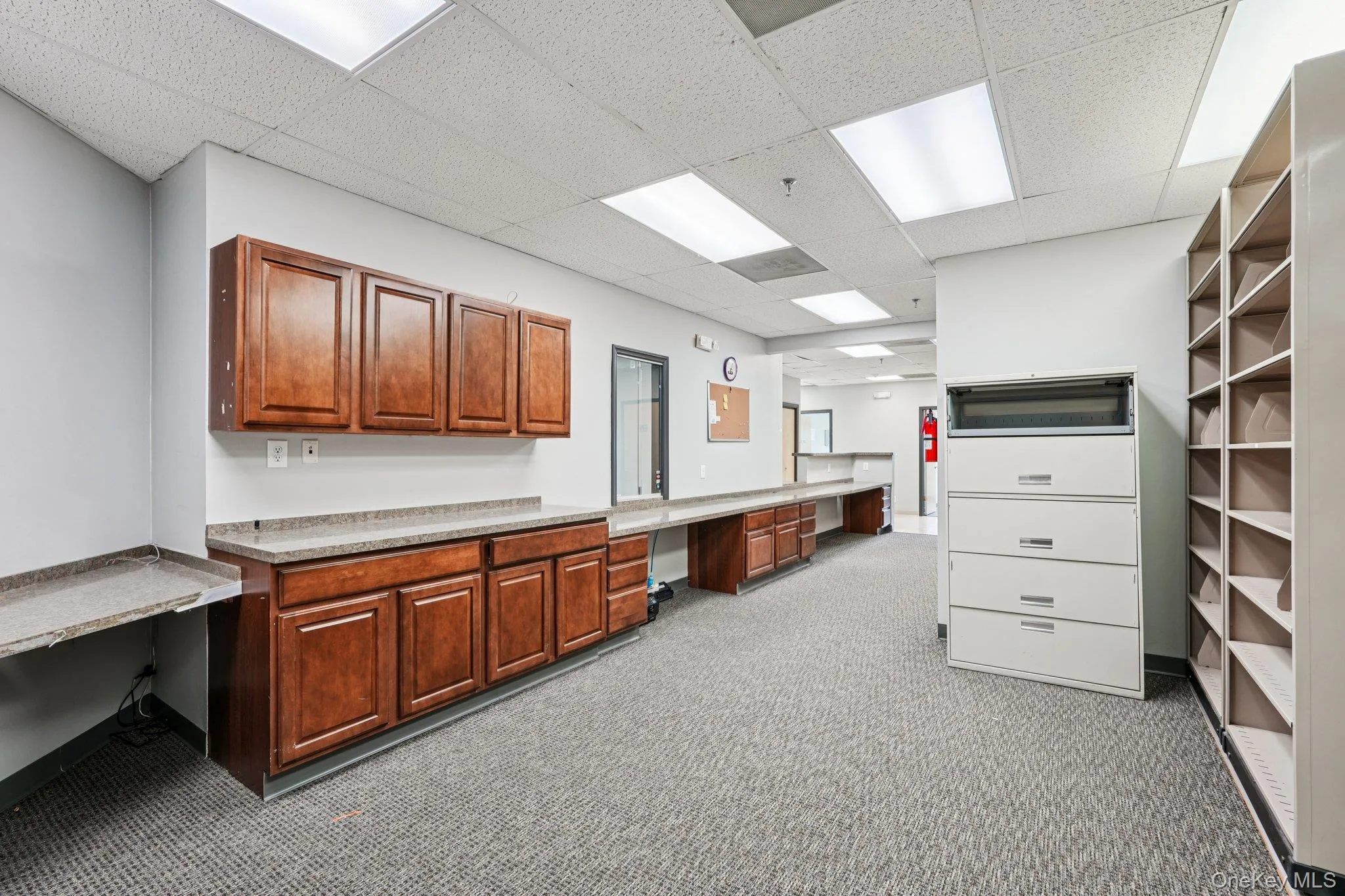 Unfurnished office with built in desk and a drop ceiling Unfurnished office with built in desk and a drop ceiling