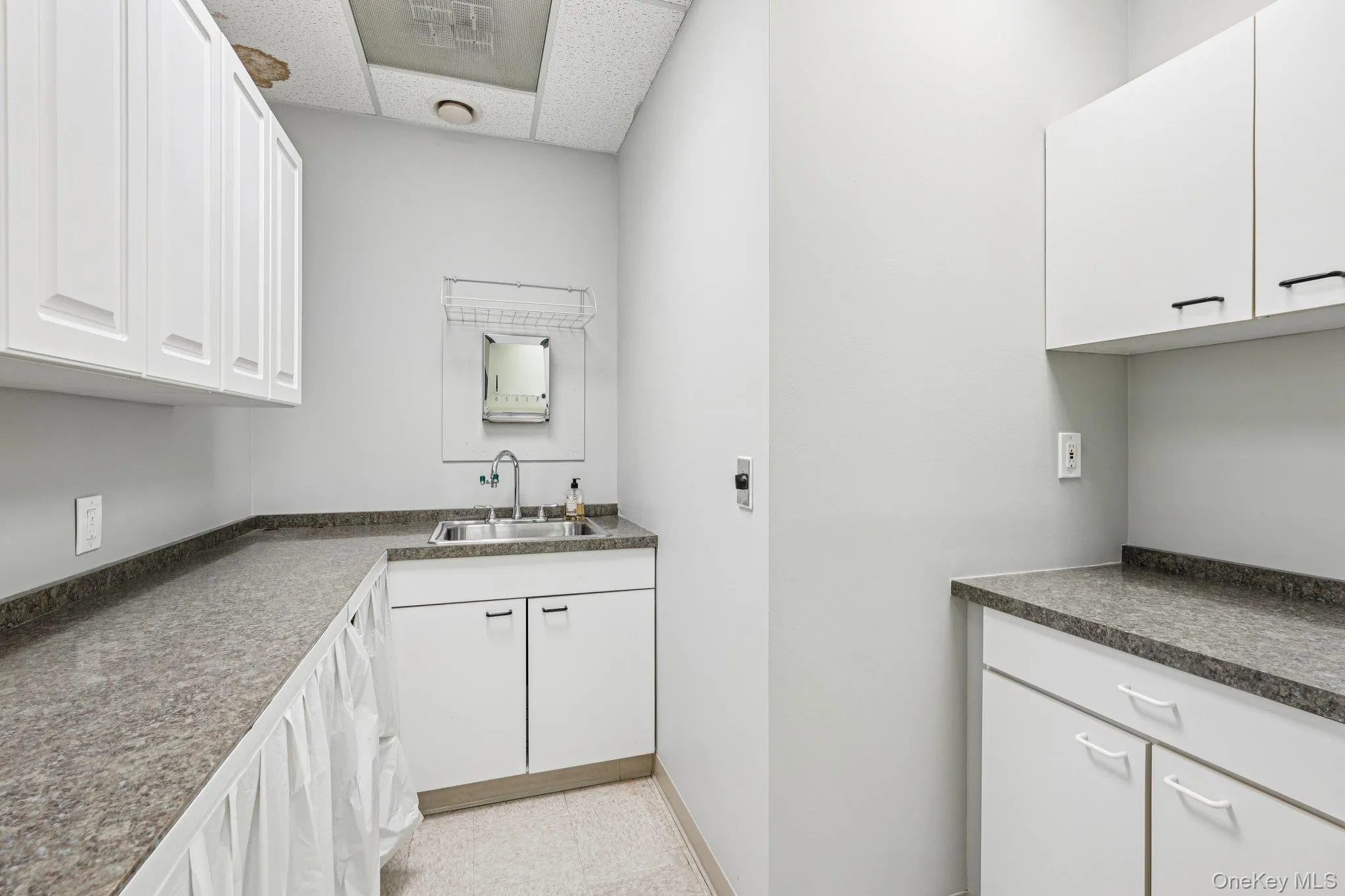 Washroom featuring a drop ceiling and a sink Washroom featuring a drop ceiling and a sink