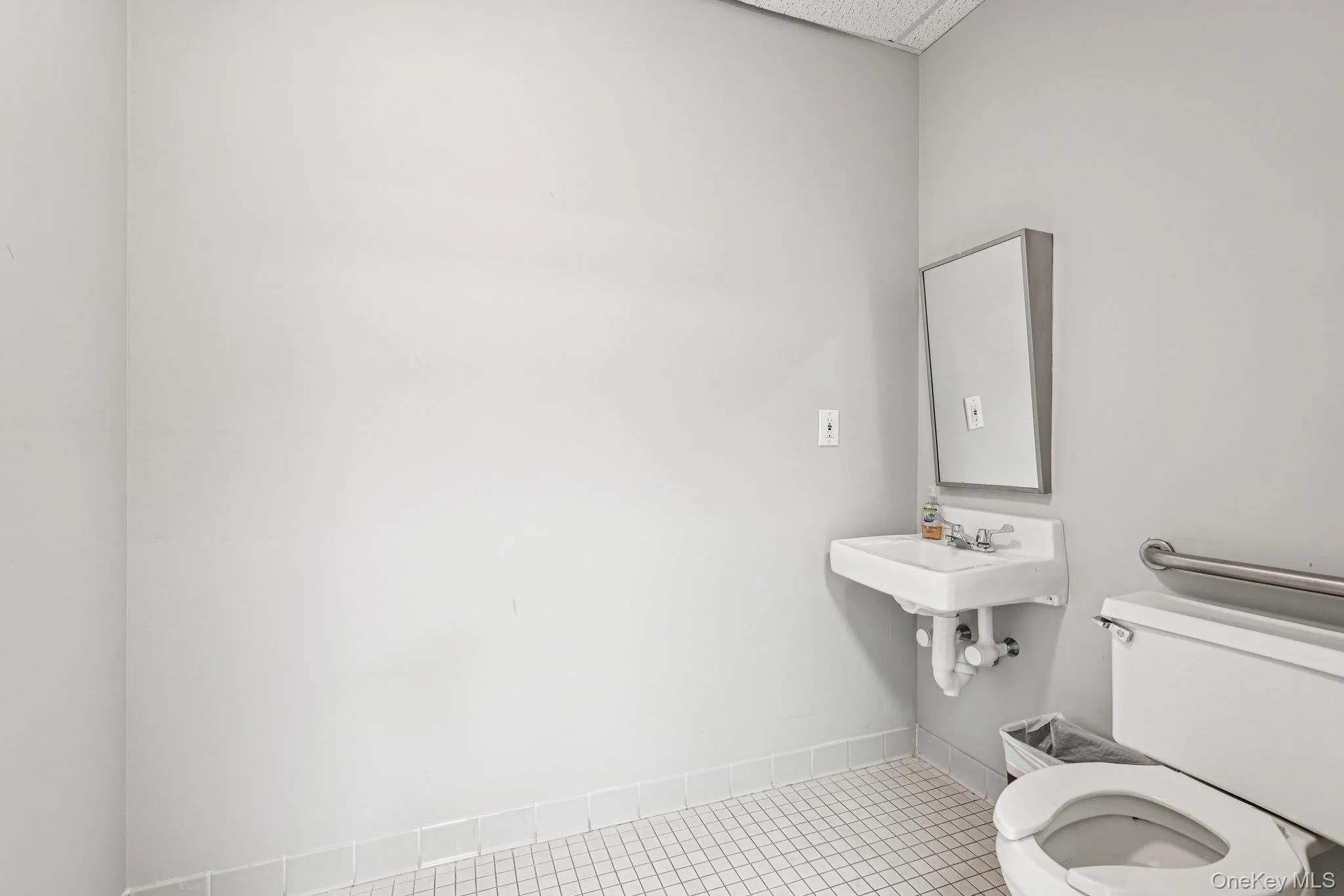 Half bathroom featuring toilet and tile patterned flooring Half bathroom featuring toilet and tile patterned flooring