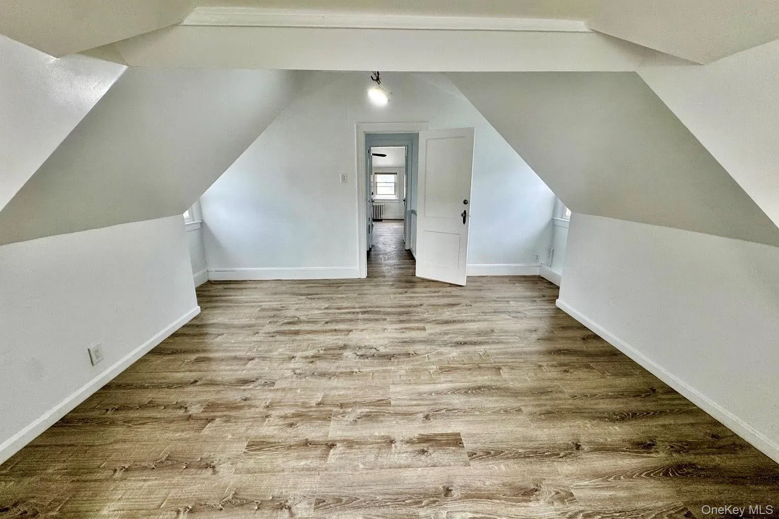 Bonus room with light wood-style flooring and vaulted ceiling Bonus room with light wood-style flooring and vaulted ceiling