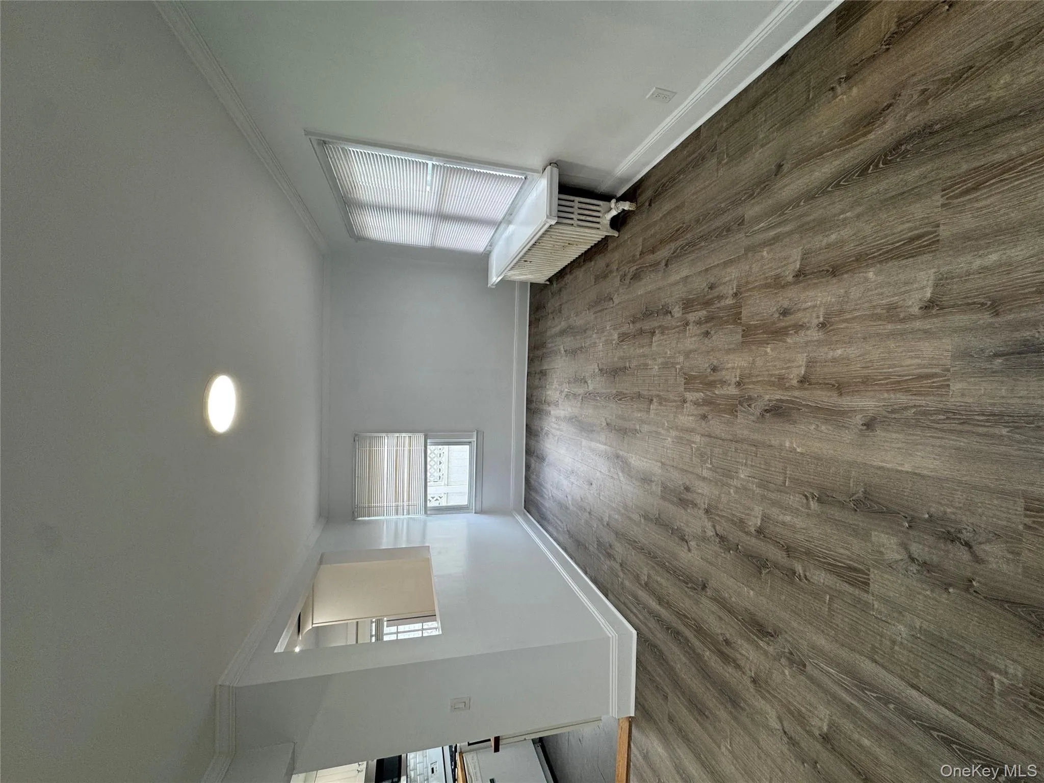Empty room with ornamental molding, dark wood finished floors, and radiator heating unit Empty room with ornamental molding, dark wood finished floors, and radiator heating unit