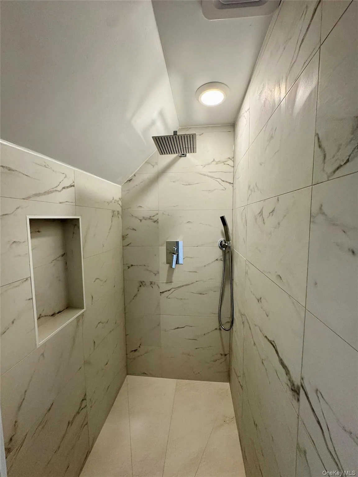 Bathroom with a marble finish shower and vaulted ceiling Bathroom with a marble finish shower and vaulted ceiling