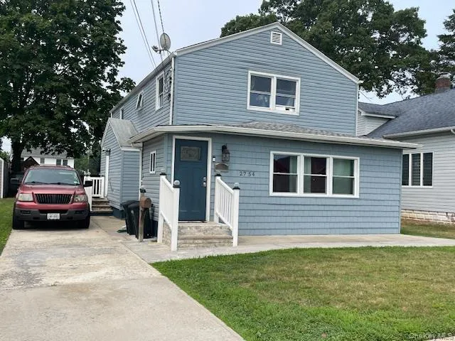 View of front of property with a front lawn, concrete driveway, and roof with shingles View of front of property with a front lawn, concrete driveway, and roof with shingles