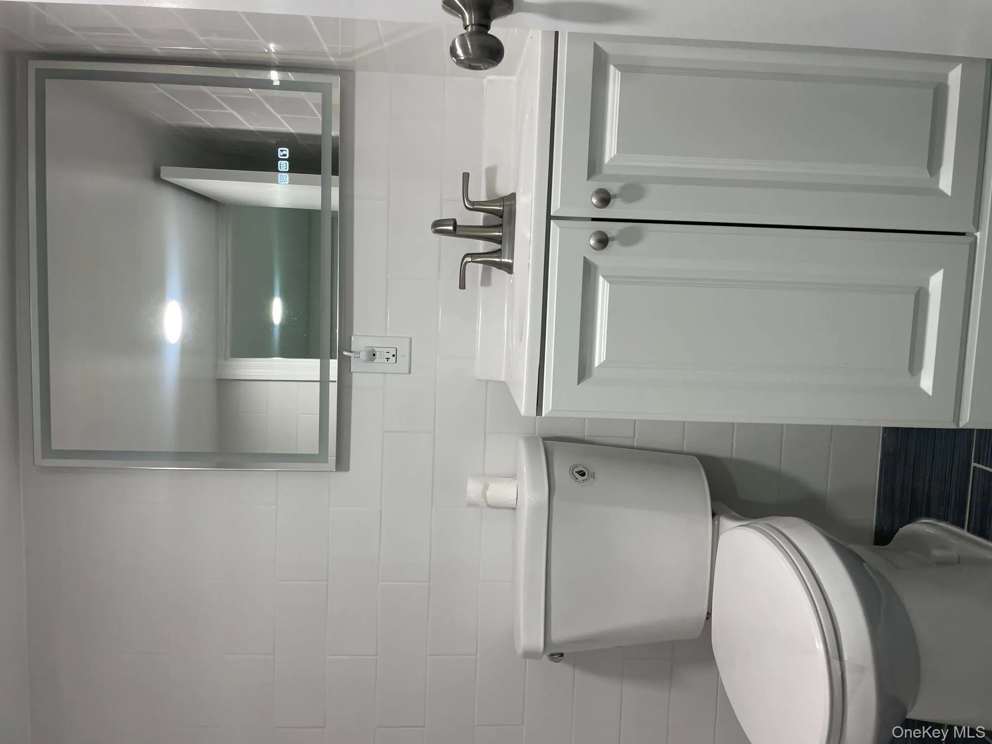 Bathroom featuring tile walls and vanity Bathroom featuring tile walls and vanity