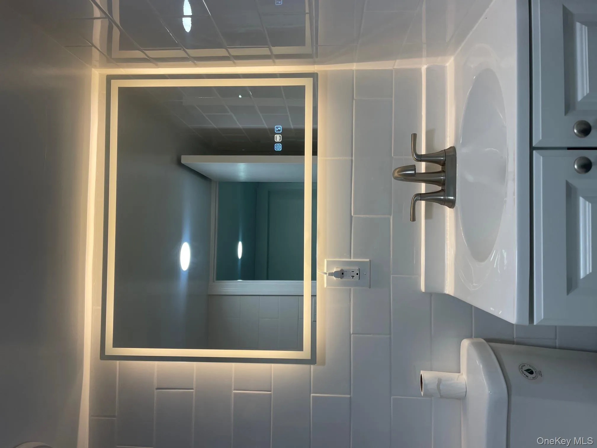 Bathroom featuring vanity, decorative backsplash, and tile walls Bathroom featuring vanity, decorative backsplash, and tile walls