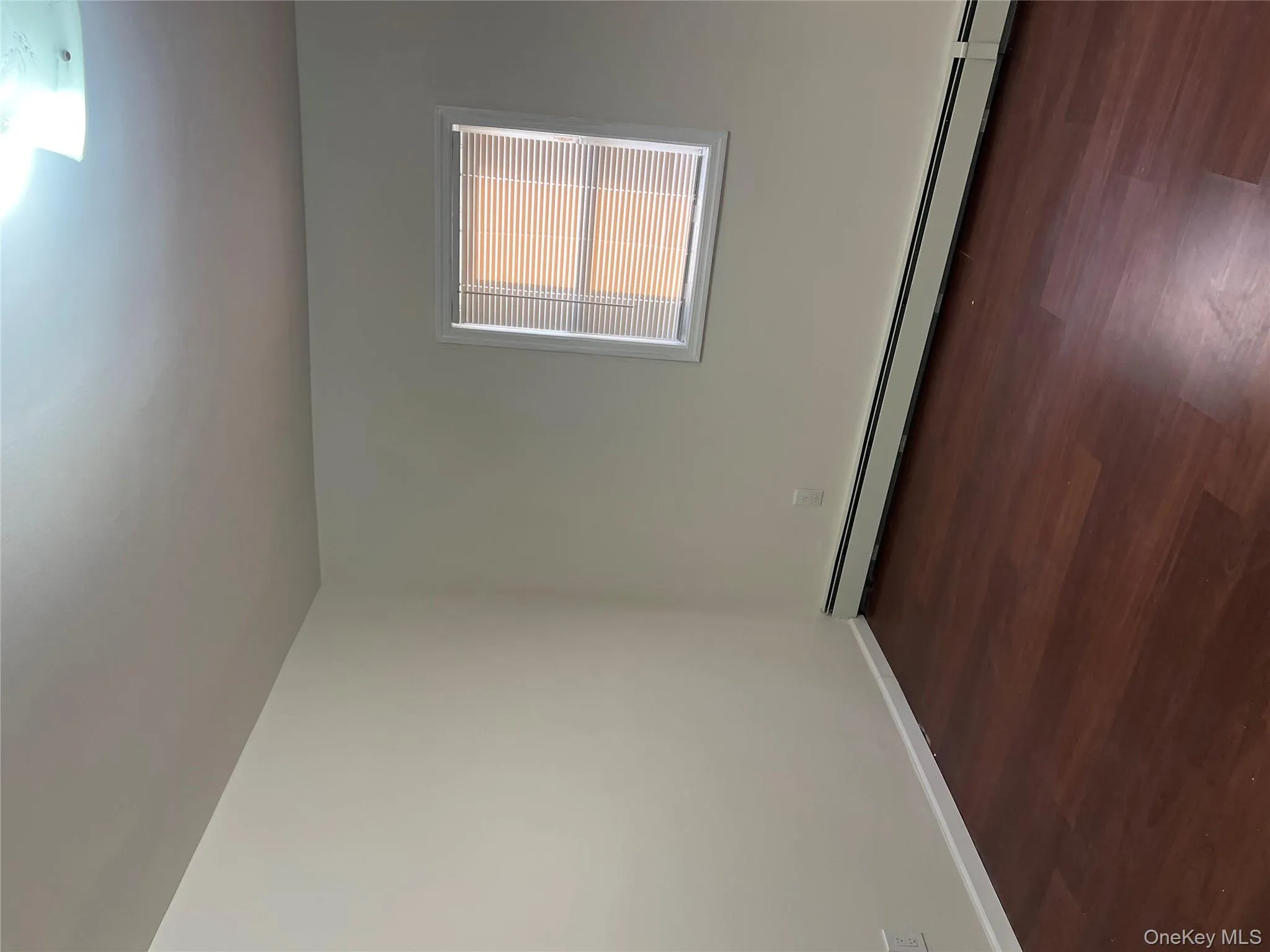 Empty room with a baseboard heating unit and dark wood finished floors Empty room with a baseboard heating unit and dark wood finished floors