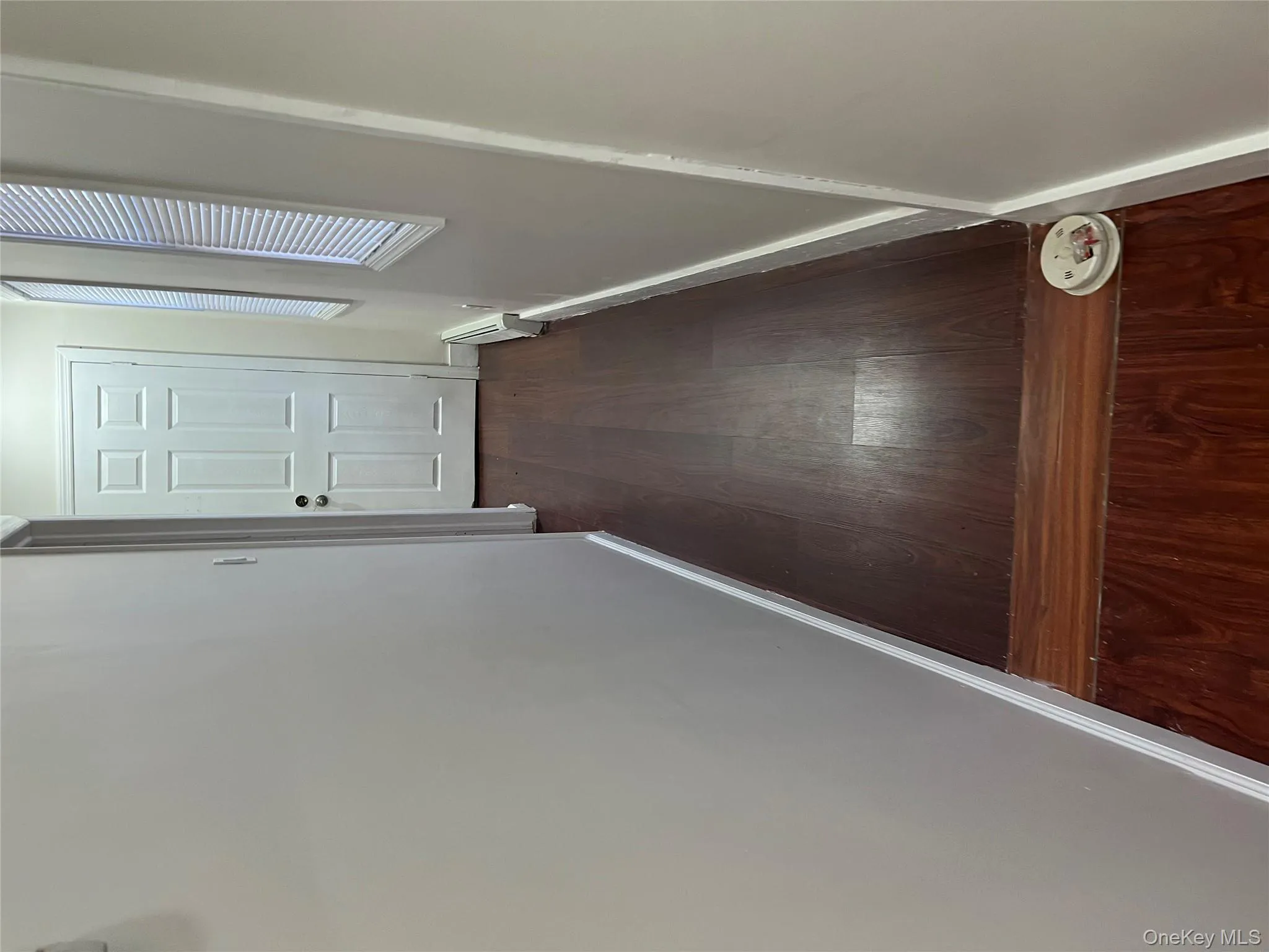 Hallway with dark wood finished floors and a baseboard radiator Hallway with dark wood finished floors and a baseboard radiator
