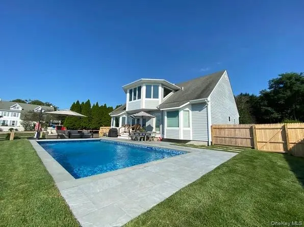 Rear view of house with an outdoor living space, a patio area, and a gate Rear view of house with an outdoor living space, a patio area, and a gate