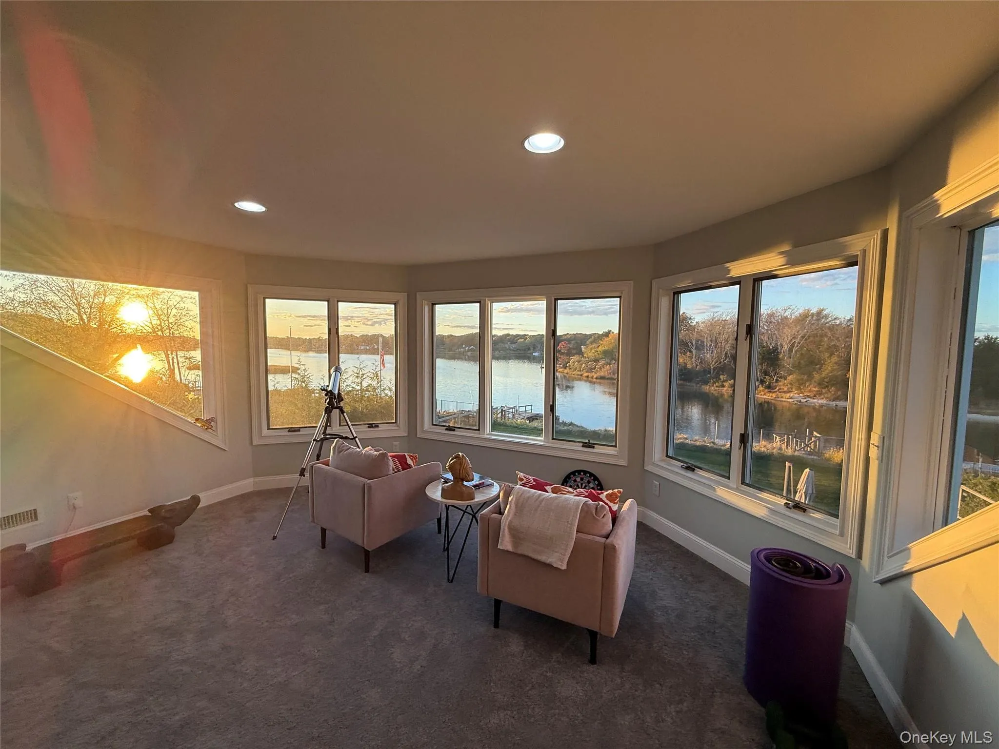Sunroom / solarium featuring a water view, carpet flooring, and recessed lighting Sunroom / solarium featuring a water view, carpet flooring, and recessed lighting