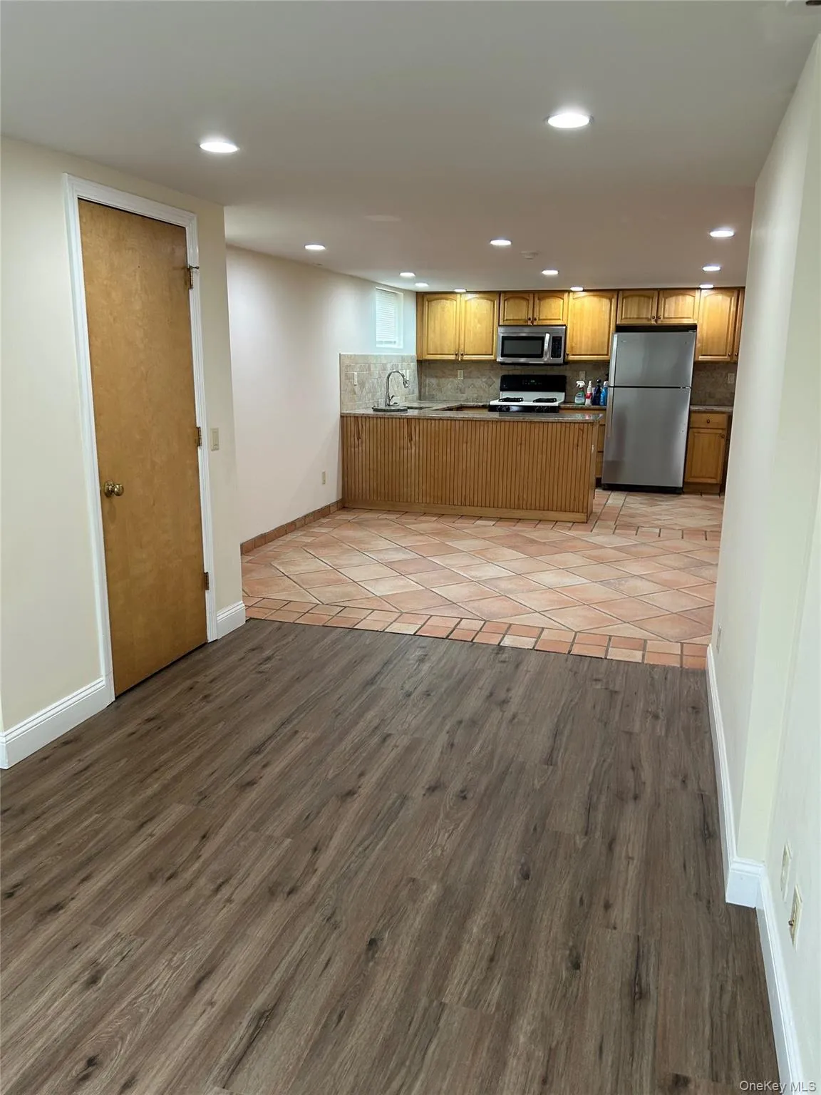 Kitchen featuring a peninsula, light wood finished floors, appliances with stainless steel finishes, brown cabinets, and recessed lighting Kitchen featuring a peninsula, light wood finished floors, appliances with stainless steel finishes, brown cabinets, and recessed lighting