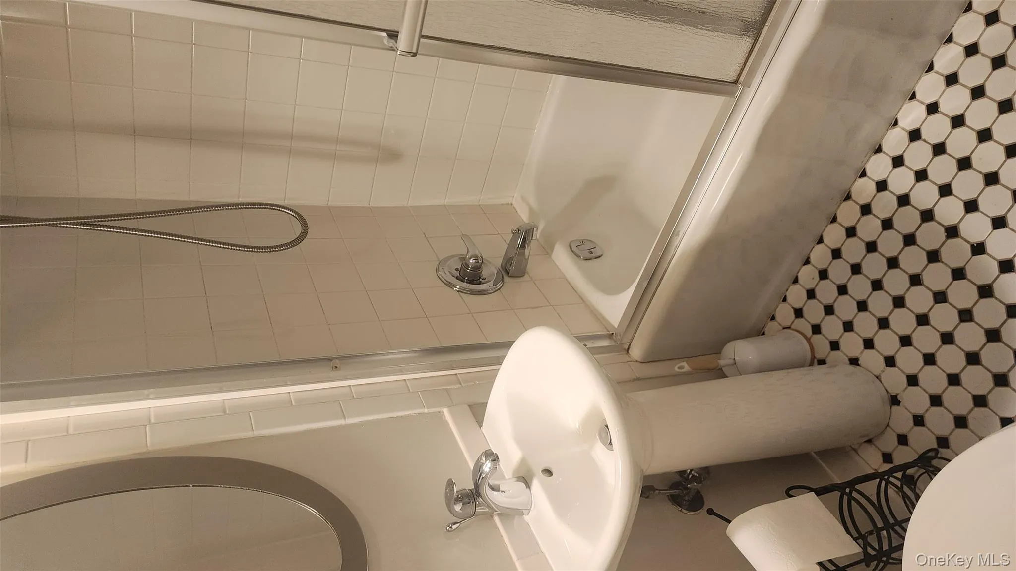 Bathroom featuring enclosed tub / shower combo and tile patterned floors Bathroom featuring enclosed tub / shower combo and tile patterned floors