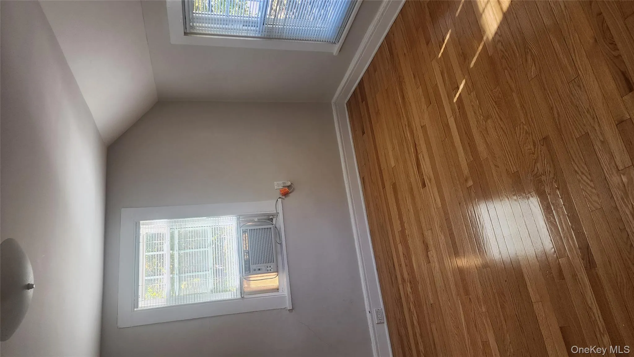 Additional living space featuring healthy amount of natural light, lofted ceiling, and hardwood / wood-style floors Additional living space featuring healthy amount of natural light, lofted ceiling, and hardwood / wood-style floors