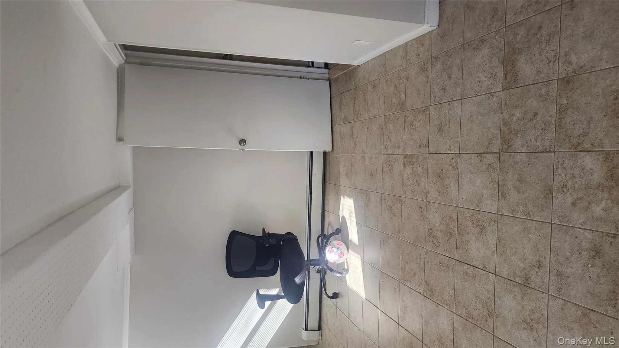 Unfurnished room featuring baseboard heating and light tile patterned floors Unfurnished room featuring baseboard heating and light tile patterned floors