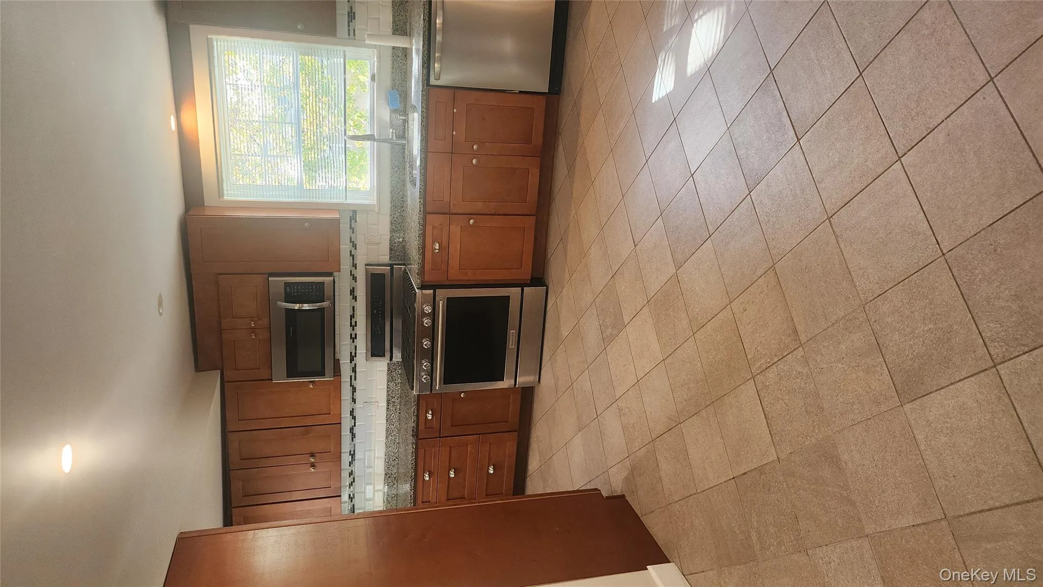 Kitchen featuring stainless steel appliances, light stone countertops, brown cabinets, tasteful backsplash, and recessed lighting Kitchen featuring stainless steel appliances, light stone countertops, brown cabinets, tasteful backsplash, and recessed lighting