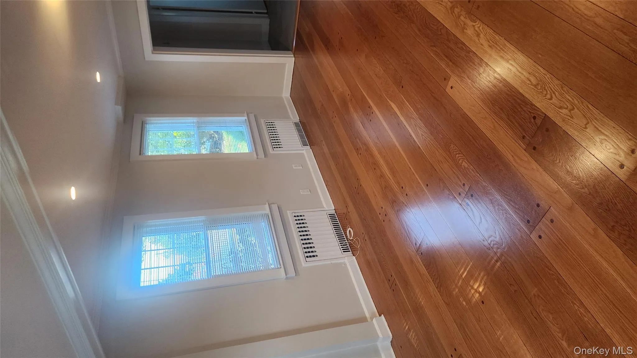 Empty room featuring ornamental molding, radiator, hardwood / wood-style flooring, and recessed lighting Empty room featuring ornamental molding, radiator, hardwood / wood-style flooring, and recessed lighting