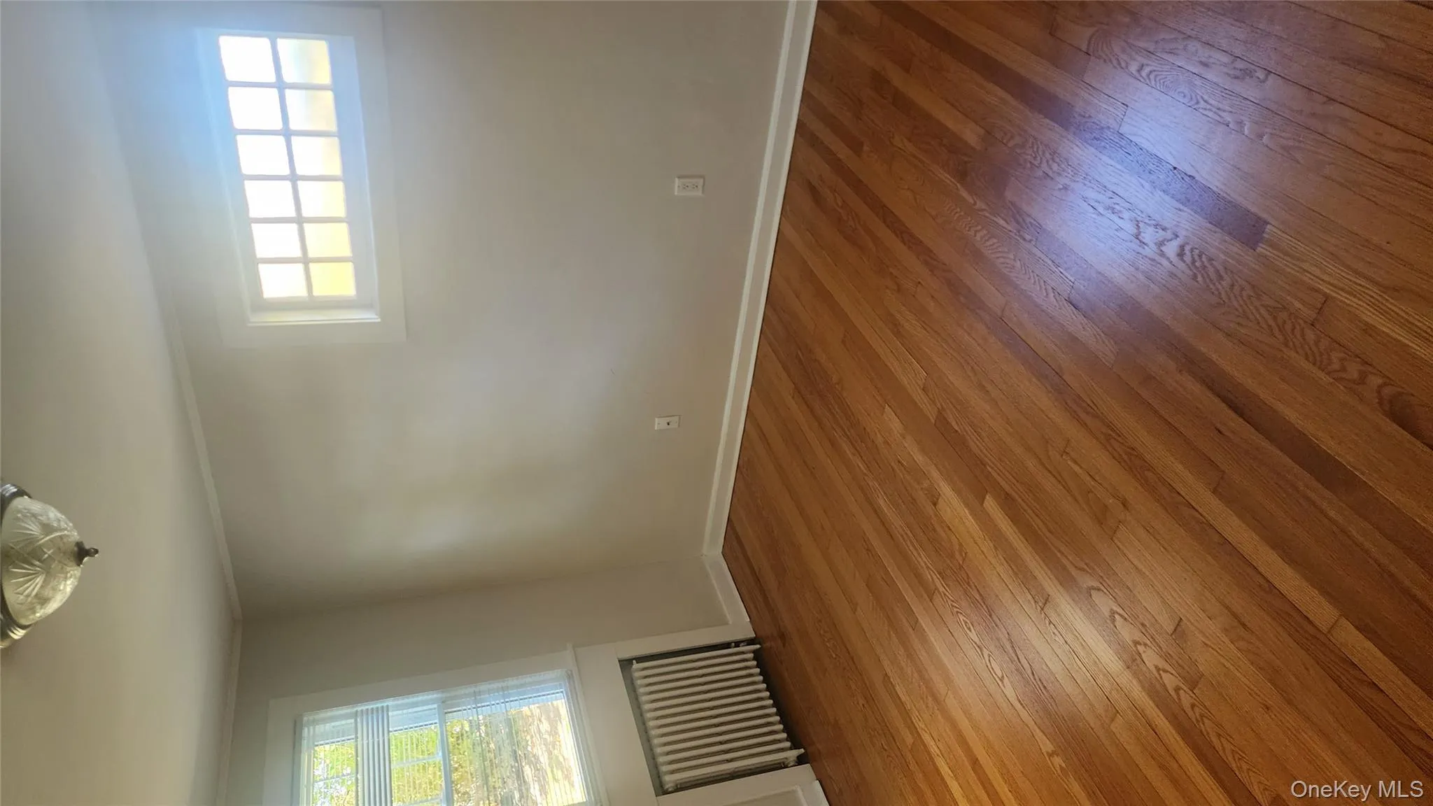 Empty room featuring plenty of natural light, radiator, hardwood / wood-style floors, and crown molding Empty room featuring plenty of natural light, radiator, hardwood / wood-style floors, and crown molding
