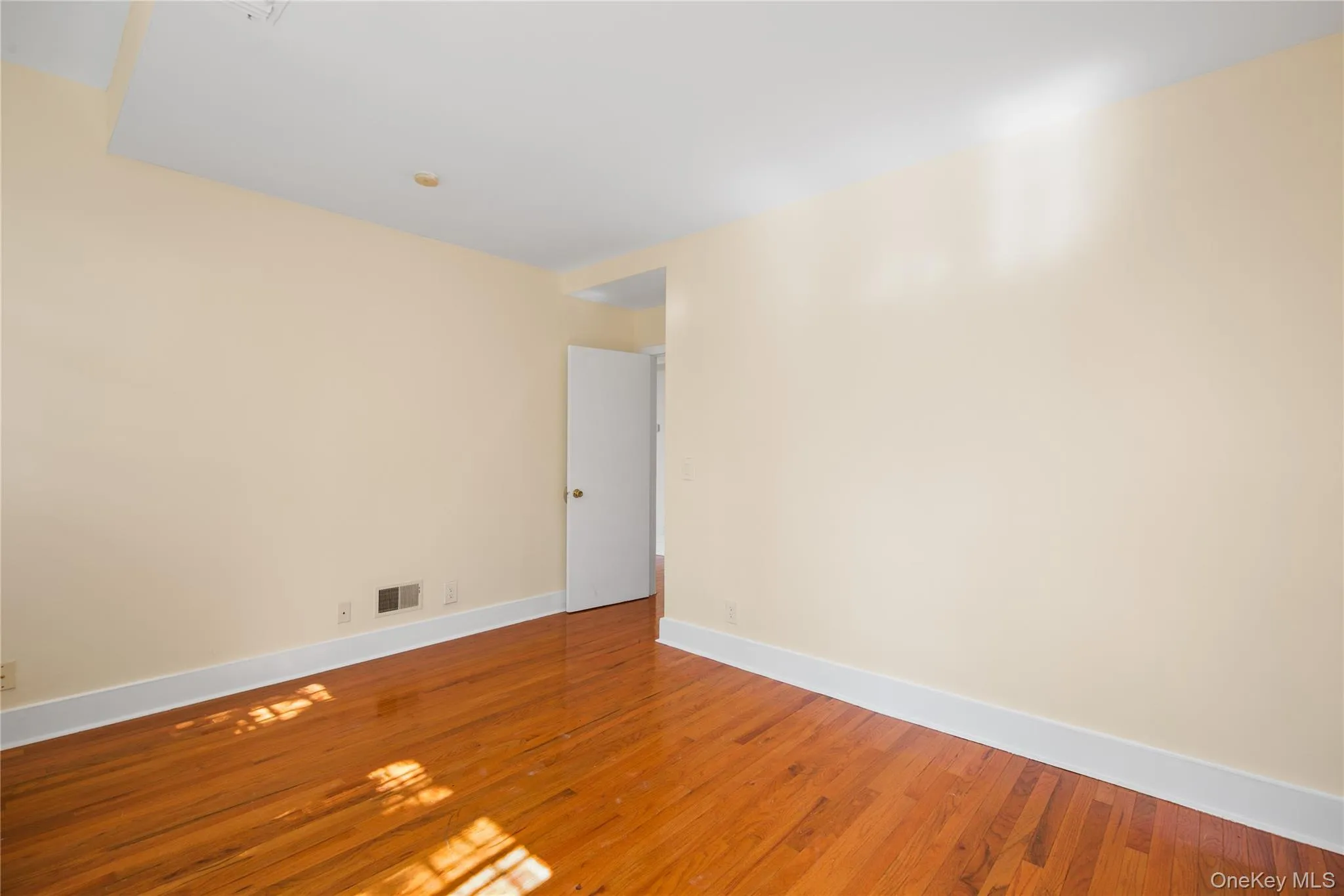 Empty room featuring wood finished floors and baseboards Empty room featuring wood finished floors and baseboards