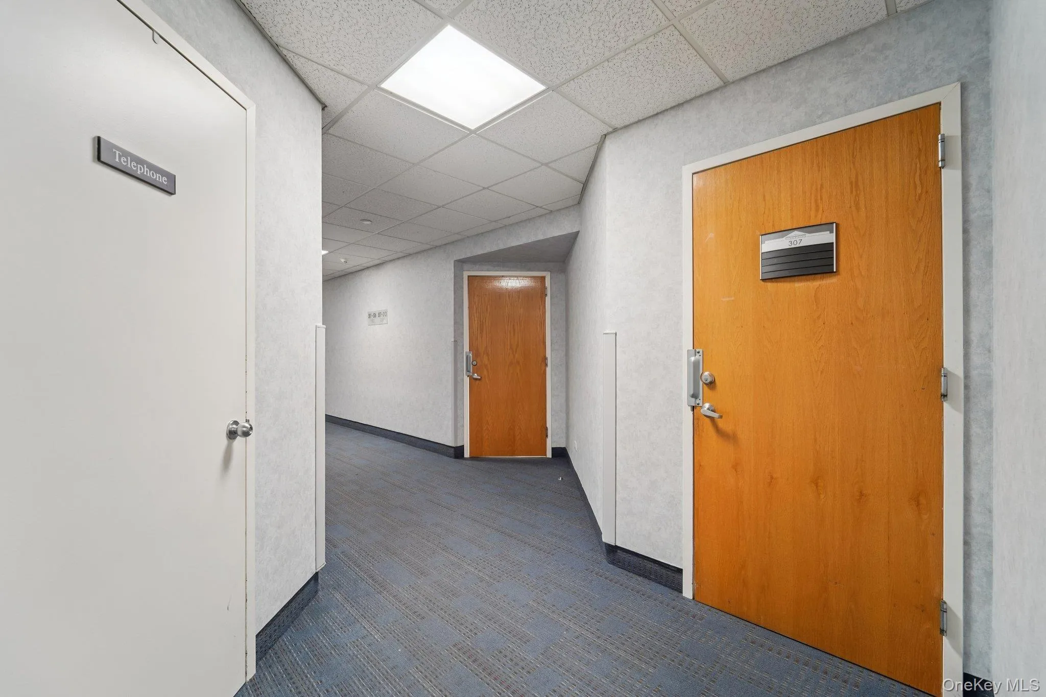 Hallway with a paneled ceiling Hallway with a paneled ceiling