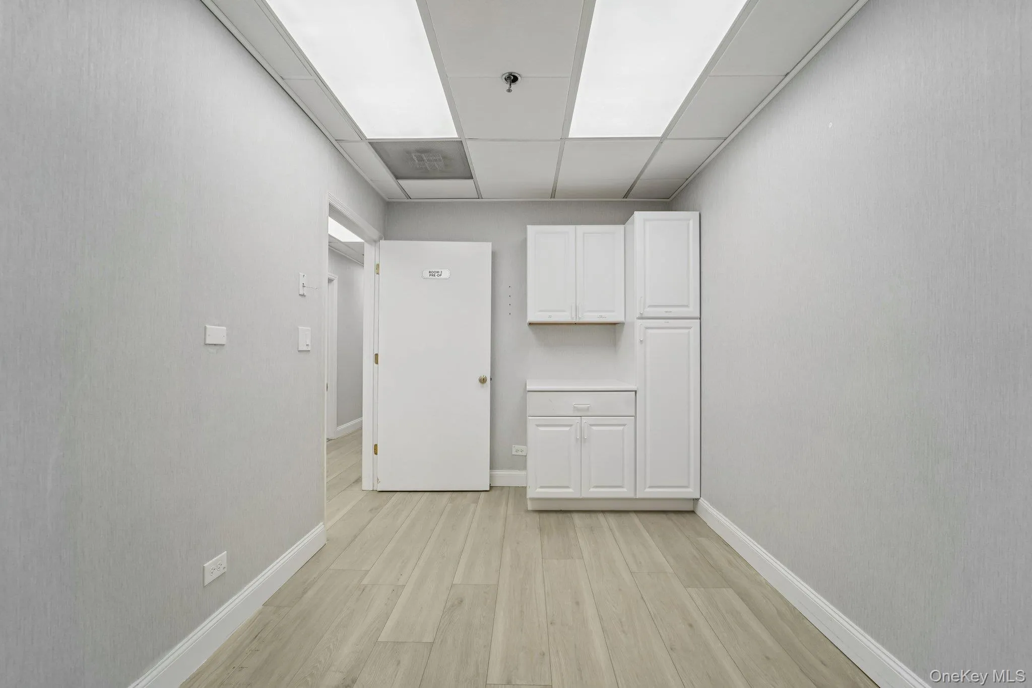 Spare room featuring a drop ceiling and light wood-style floors Spare room featuring a drop ceiling and light wood-style floors