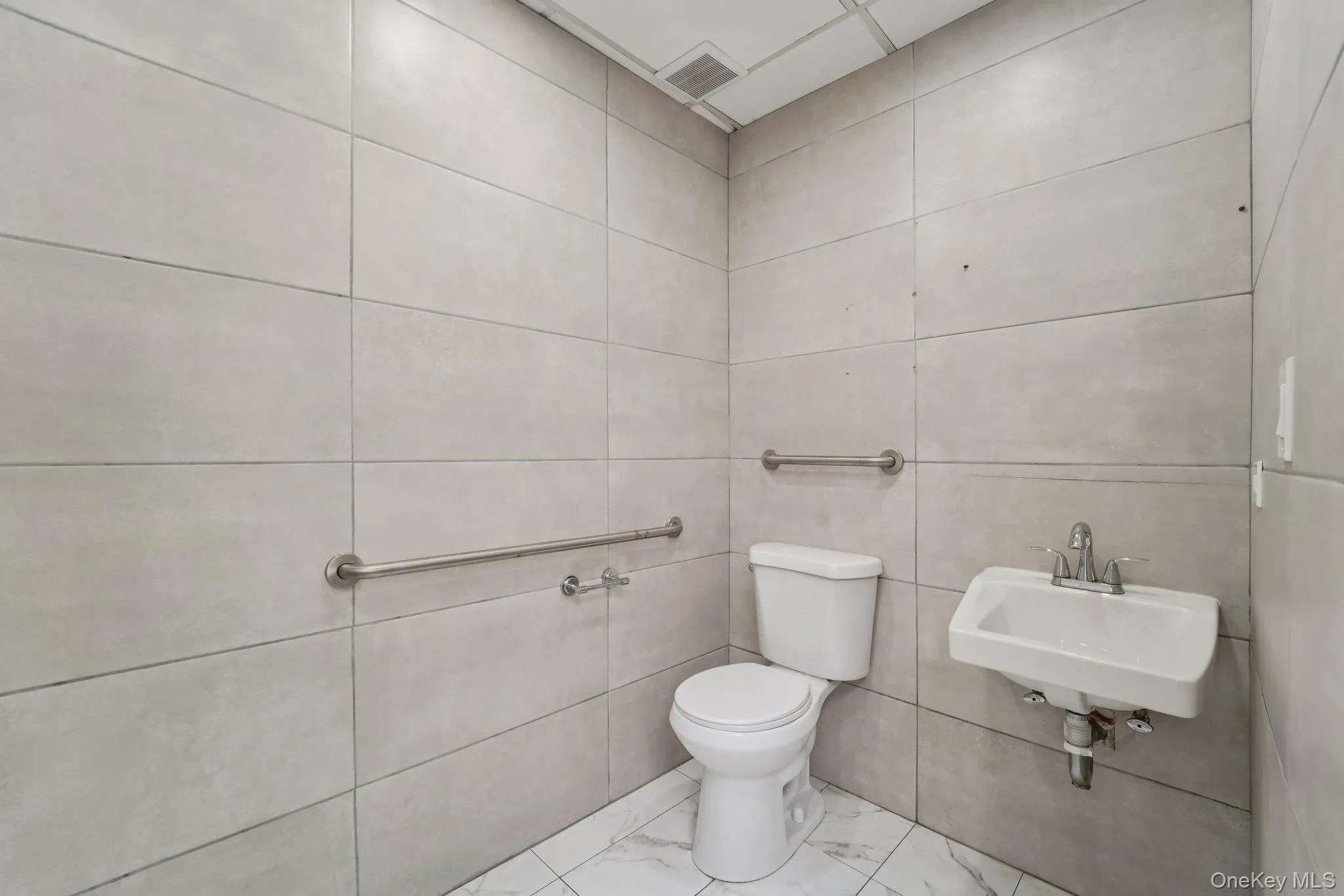 Bathroom with toilet and marble finish floors Bathroom with toilet and marble finish floors