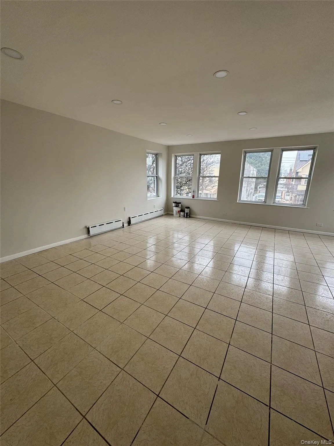 Spare room with recessed lighting, light tile patterned flooring, and a baseboard radiator Spare room with recessed lighting, light tile patterned flooring, and a baseboard radiator