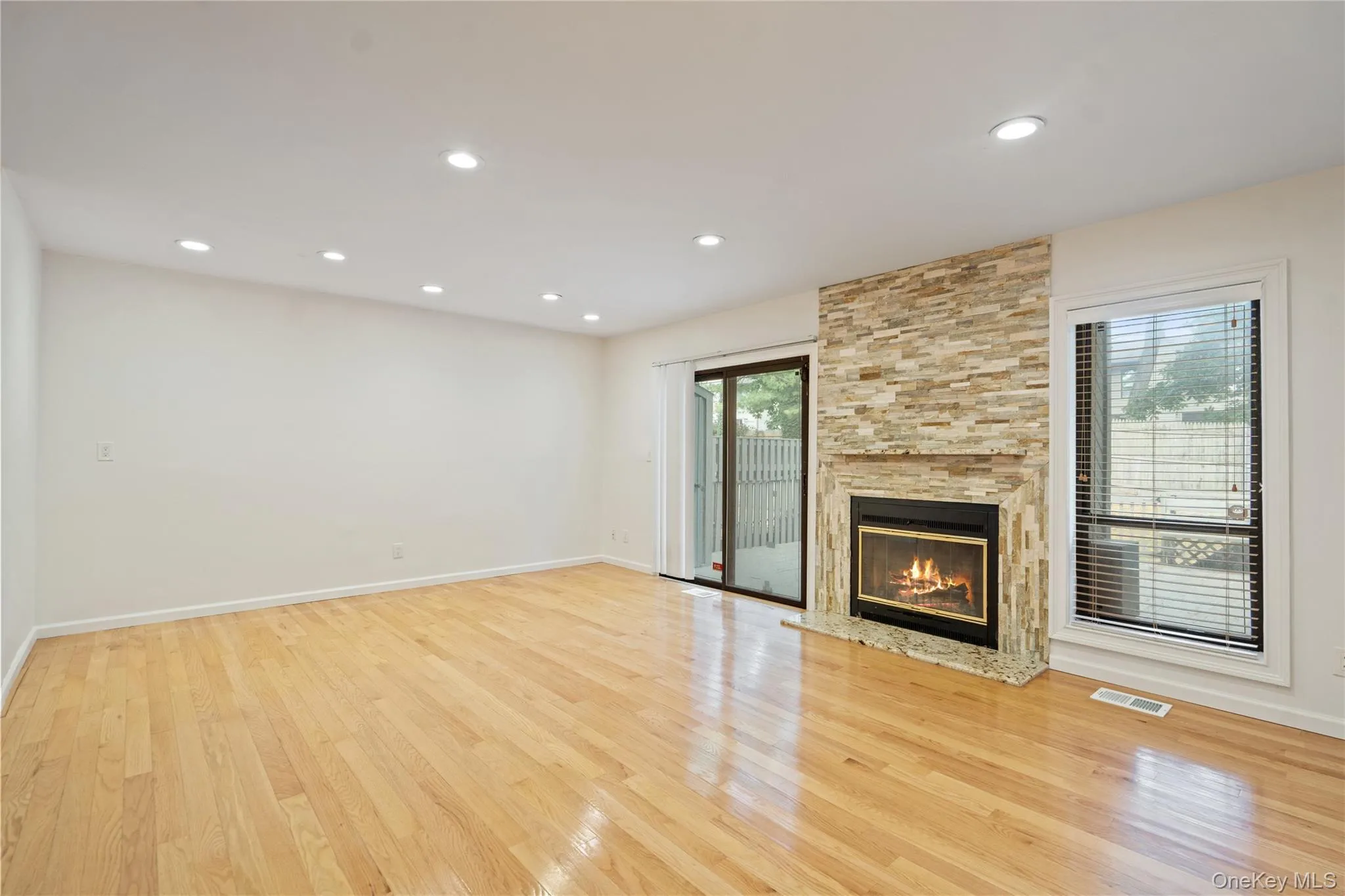 Unfurnished living room featuring a fireplace, light wood-style floors, and recessed lighting Unfurnished living room featuring a fireplace, light wood-style floors, and recessed lighting