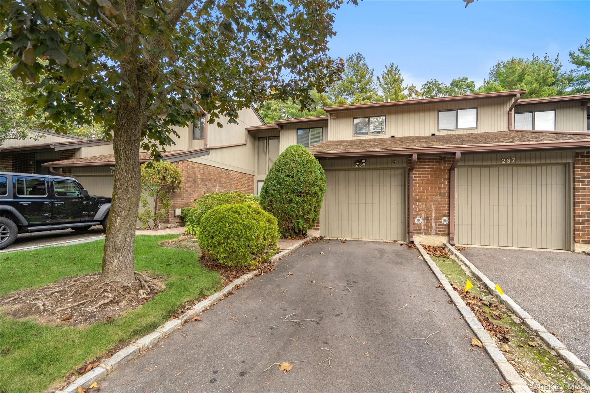 View of front of home with brick siding, asphalt driveway, and a garage View of front of home with brick siding, asphalt driveway, and a garage