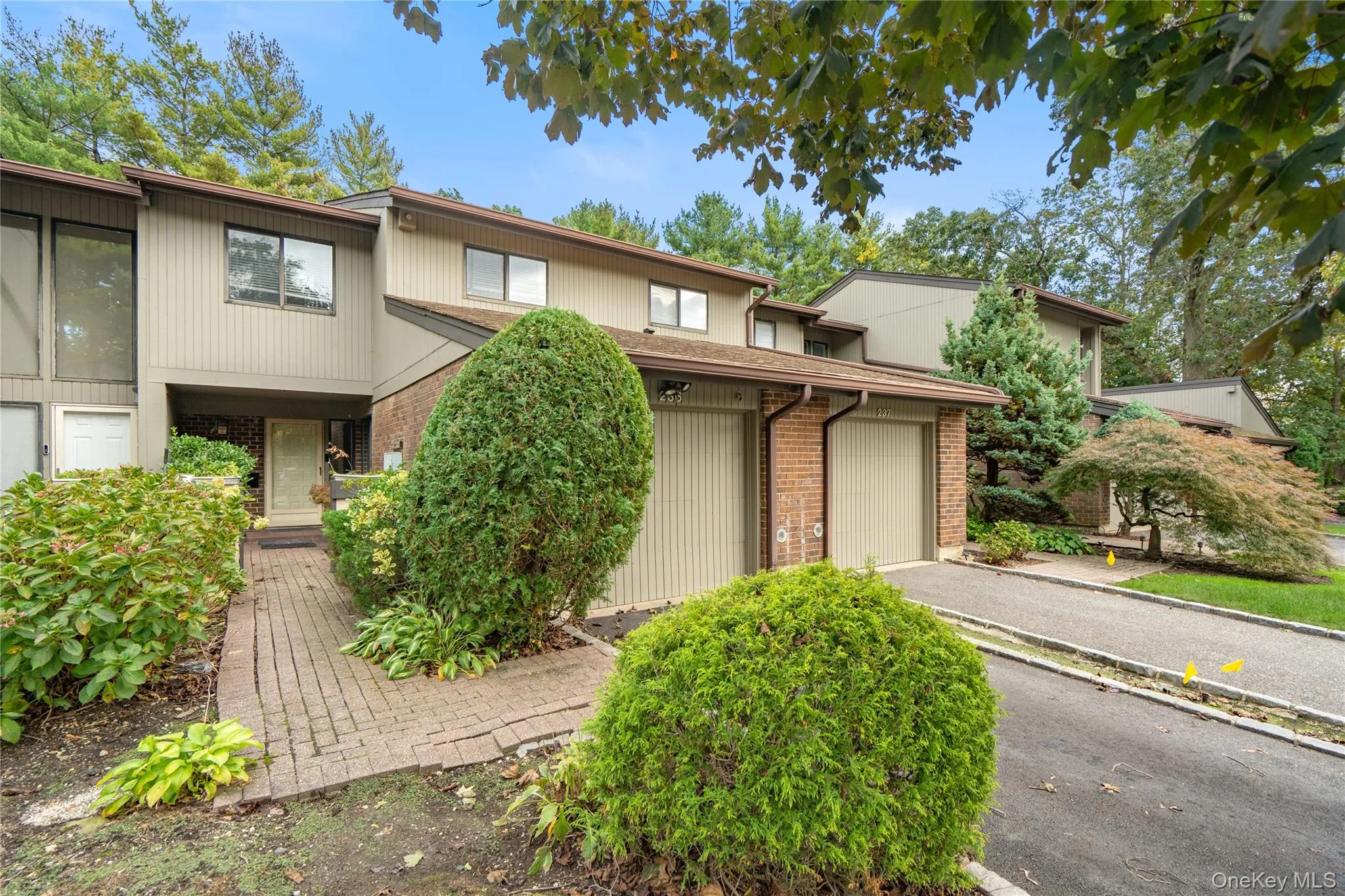 View of front of property featuring brick siding, a garage, and asphalt driveway View of front of property featuring brick siding, a garage, and asphalt driveway