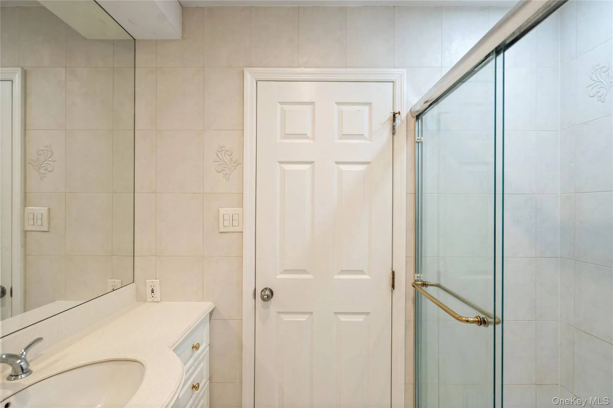 Full bath featuring vanity, tile walls, and a stall shower Full bath featuring vanity, tile walls, and a stall shower