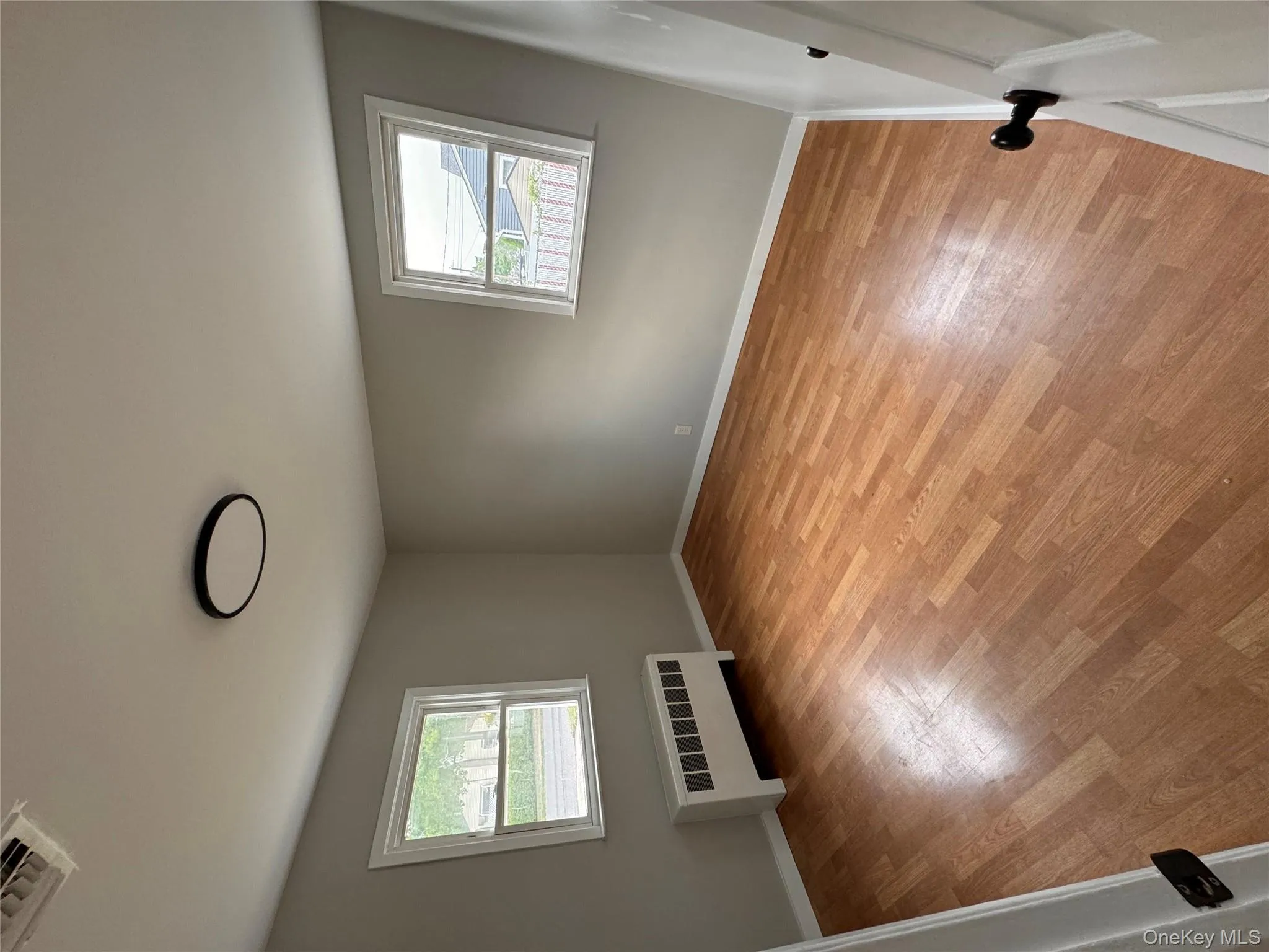 Empty room featuring radiator and light wood-style floors Empty room featuring radiator and light wood-style floors