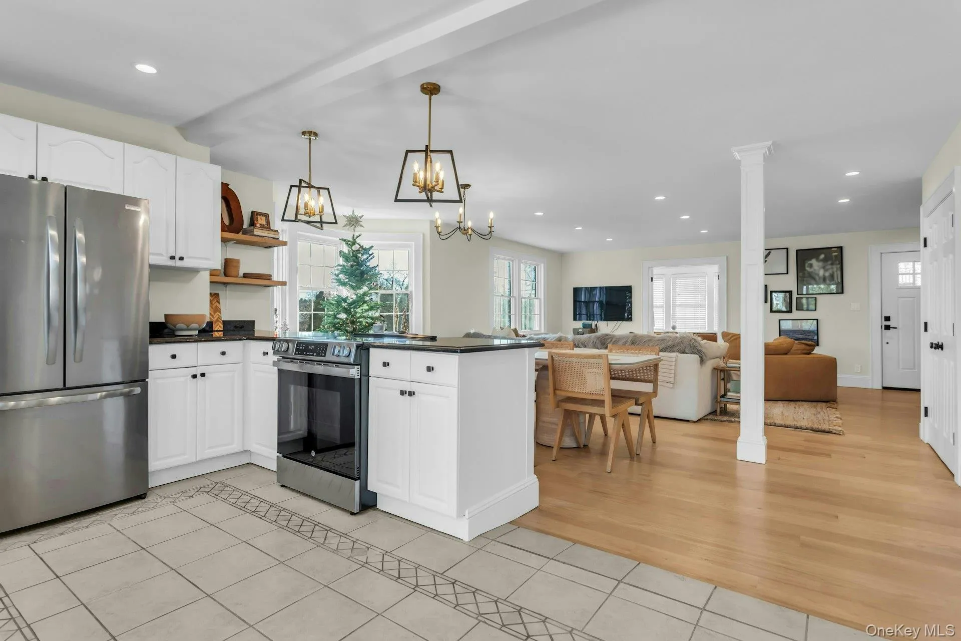 Kitchen featuring stainless steel appliances, white cabinets, recessed lighting, light tile patterned flooring, and open floor plan Kitchen featuring stainless steel appliances, white cabinets, recessed lighting, light tile patterned flooring, and open floor plan