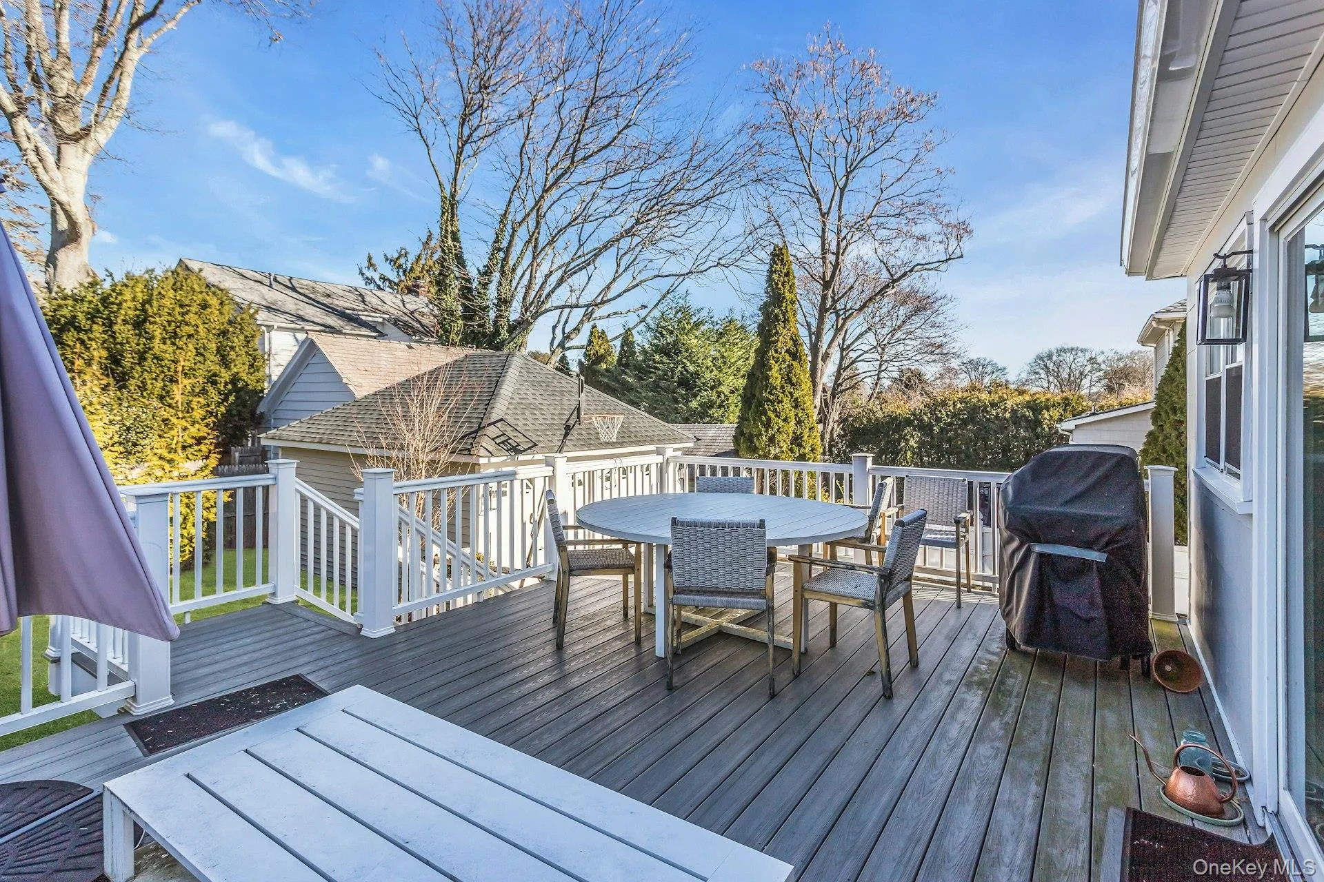 Wooden deck with outdoor dining space and a grill Wooden deck with outdoor dining space and a grill